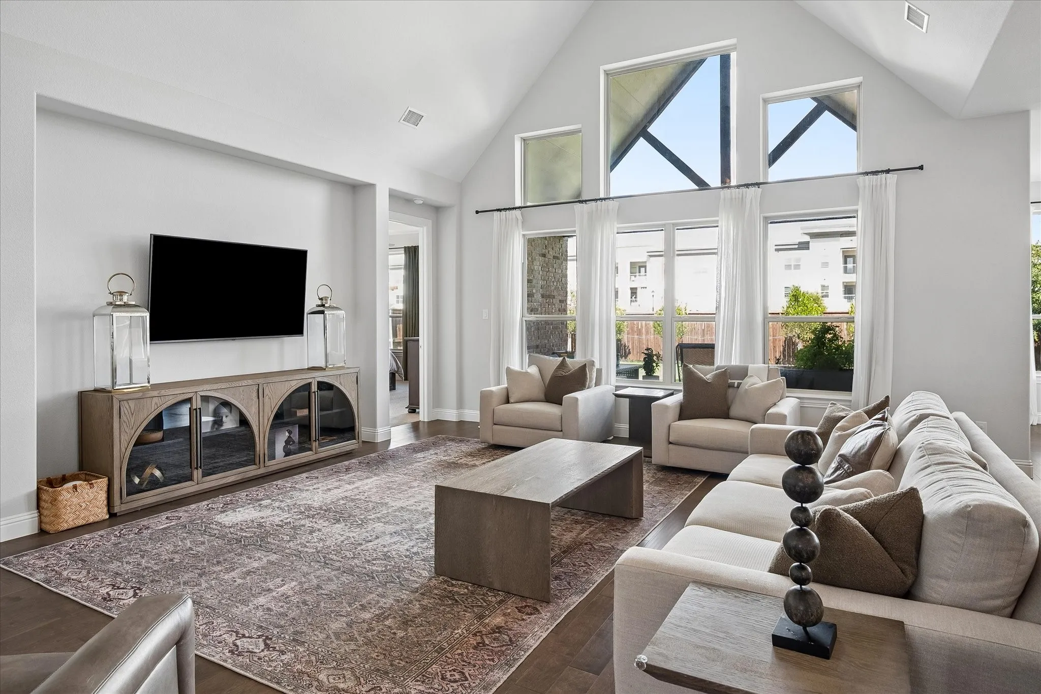 Vaulted ceilings, wood-finish flooring, extensive window array, recessed wall niche, and an open-concept layout