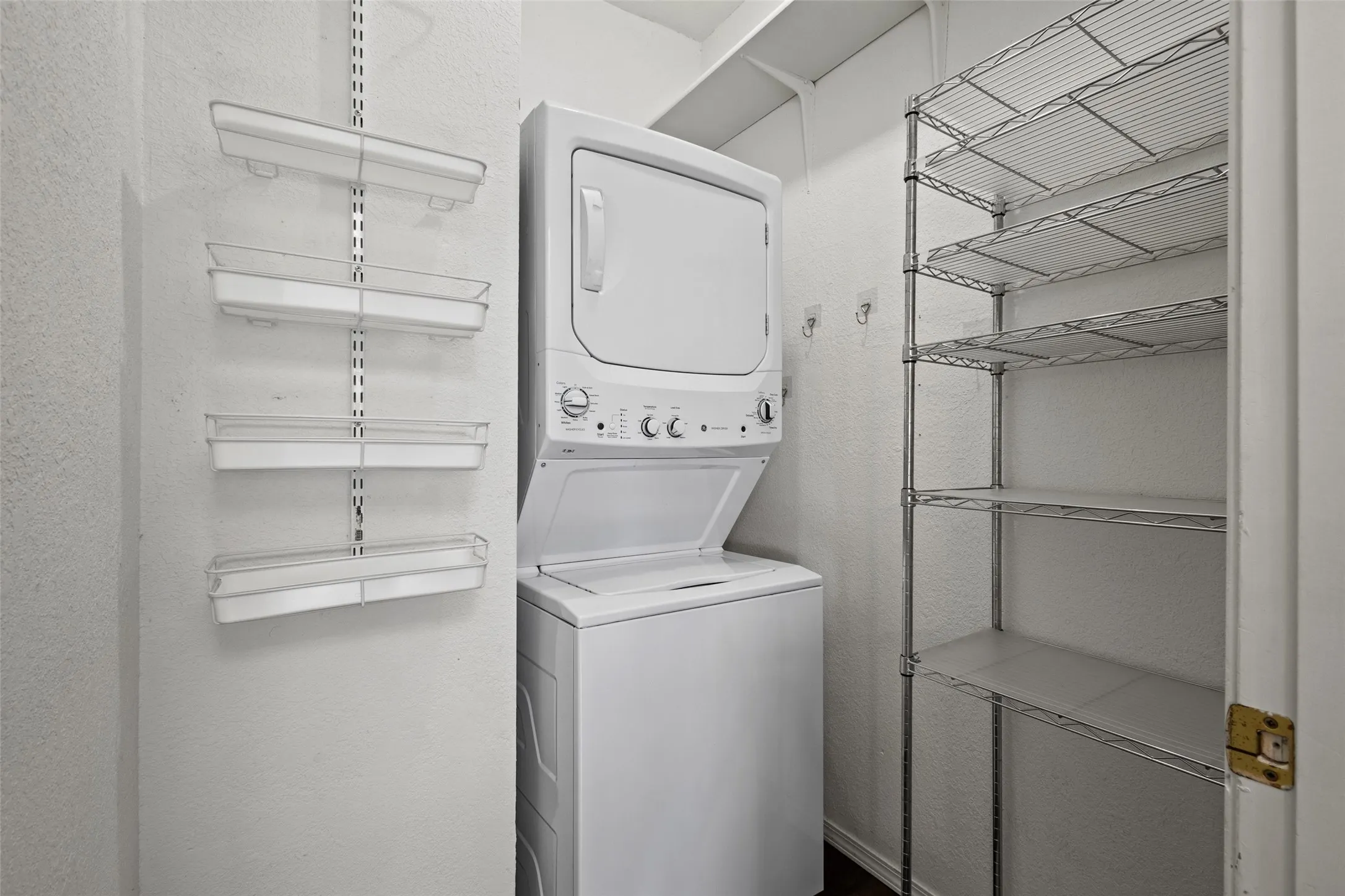 Stackable washer and dryer unit, wire shelving storage, wall-mounted adjustable shelving, and overhead shelving