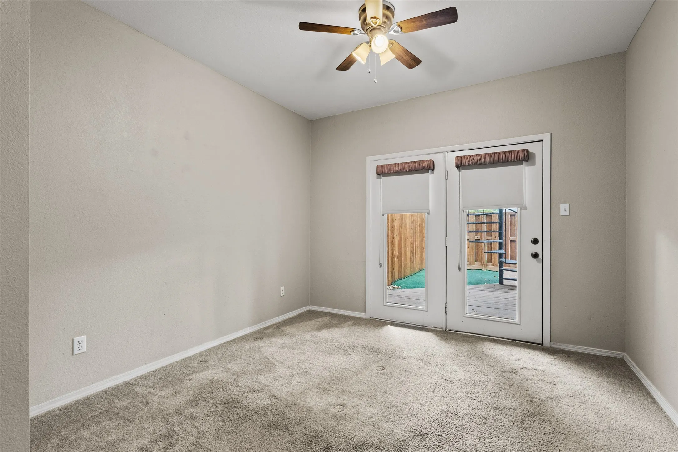 Vaulted ceiling with a ceiling fan, light gray wall paint, and gray carpeting