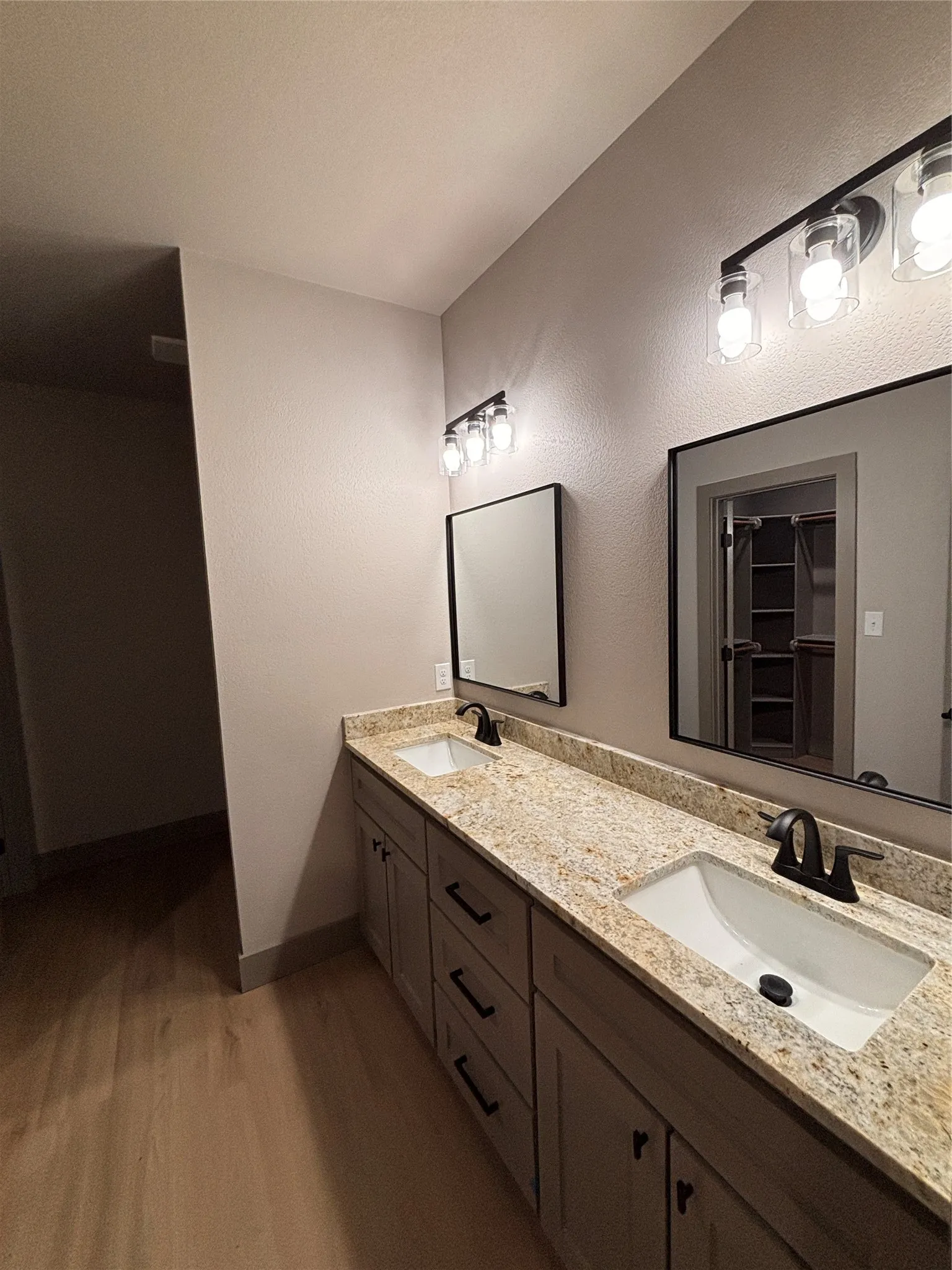 Double vanity with granite countertops, undermount sinks, and matte black fixtures