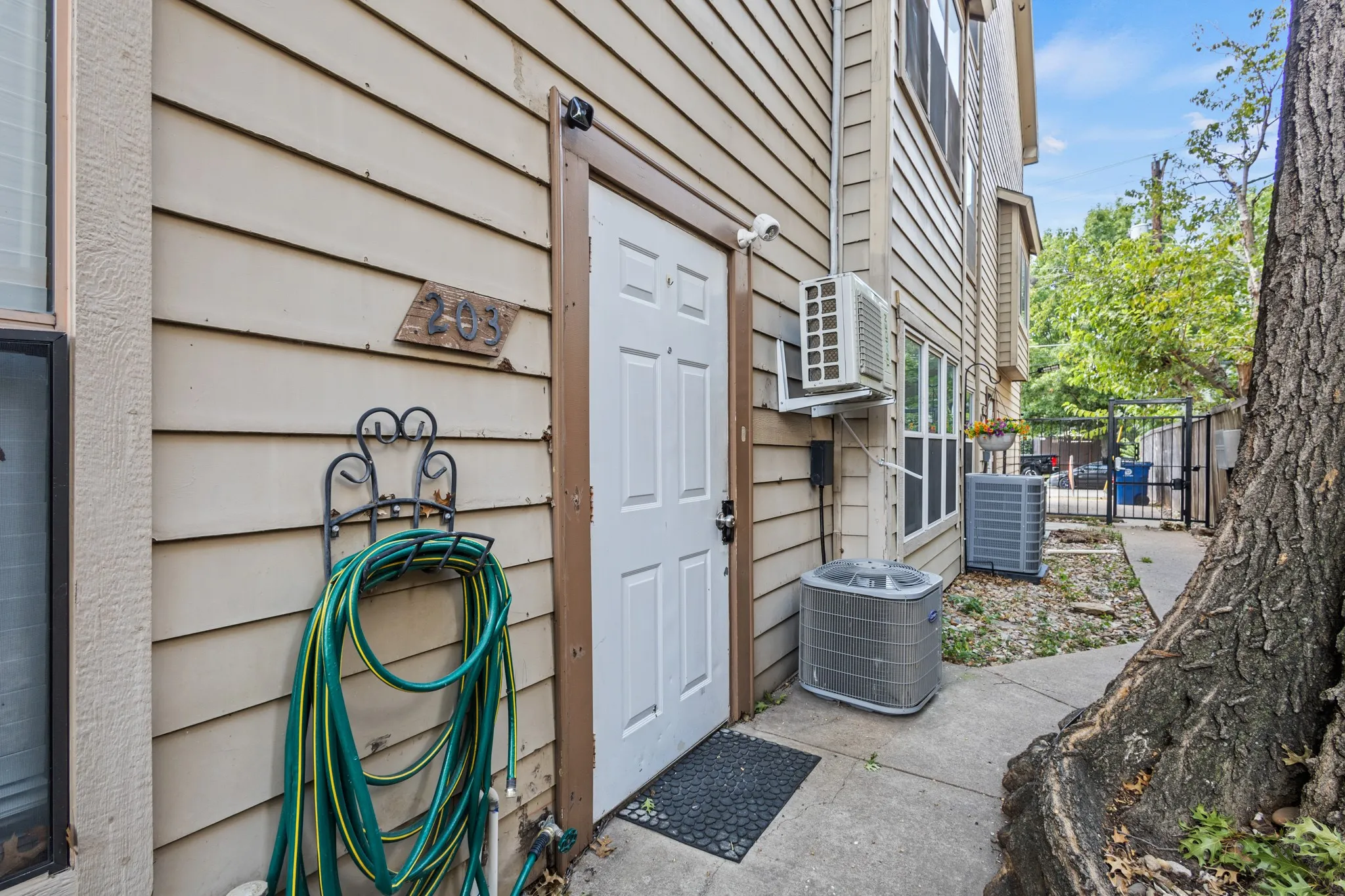 Siding exterior with multiple AC units and concrete pathway