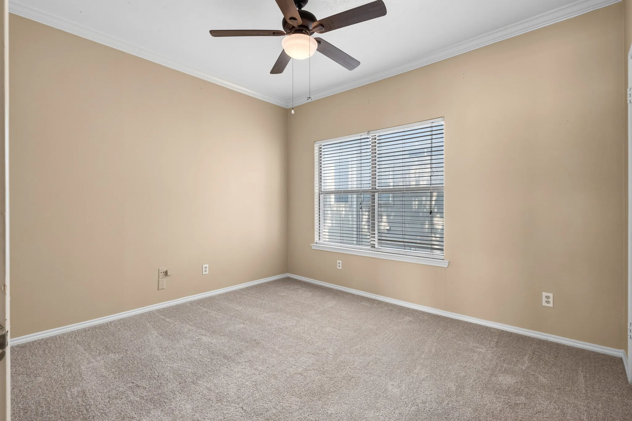 Neutral tone walls, ceiling fan with integrated lighting, window with blinds, and light-toned carpeting