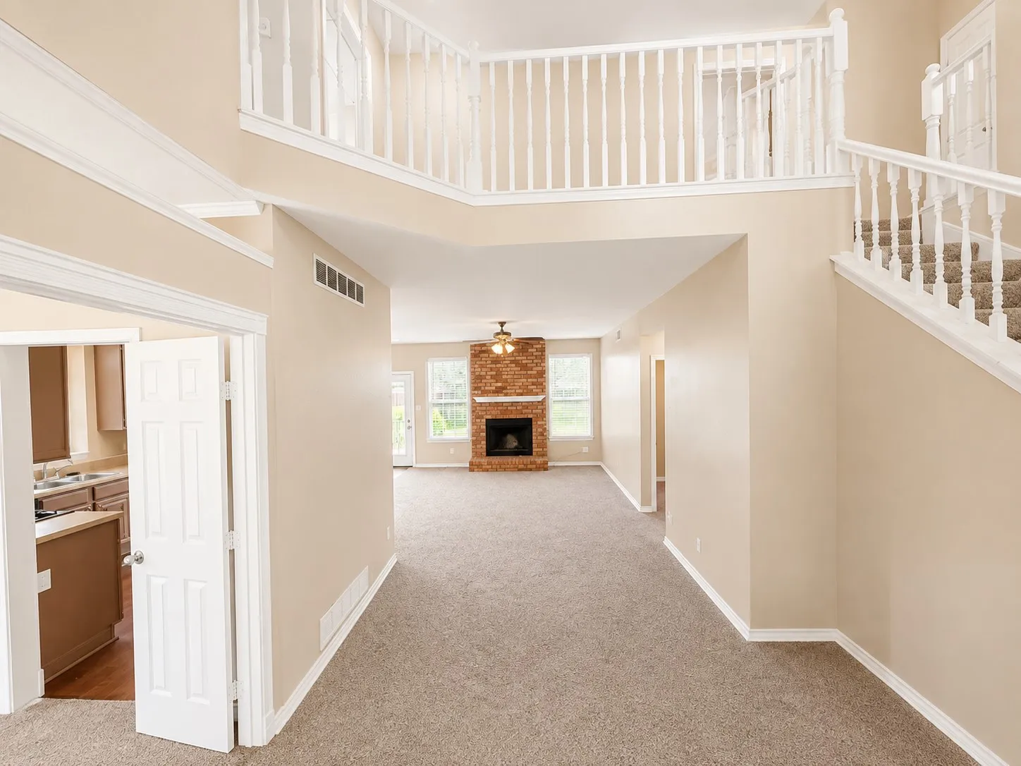 Two-story foyer with a carpeted staircase and an upper-level railing