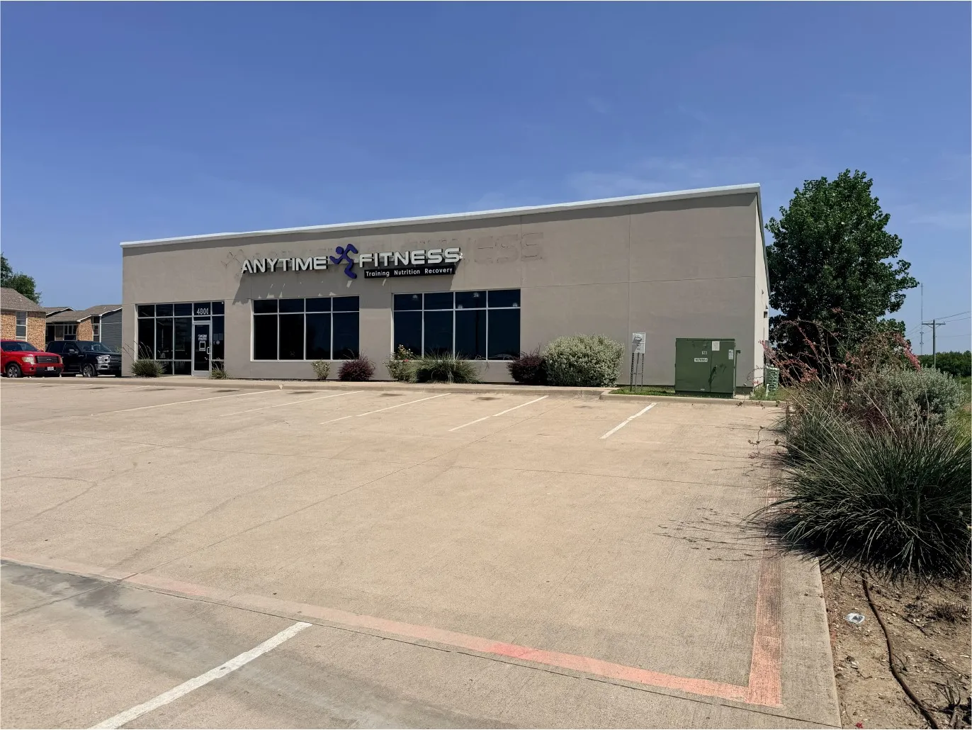 Commercial building with a neutral-toned facade, expansive front windows, and dedicated paved parking