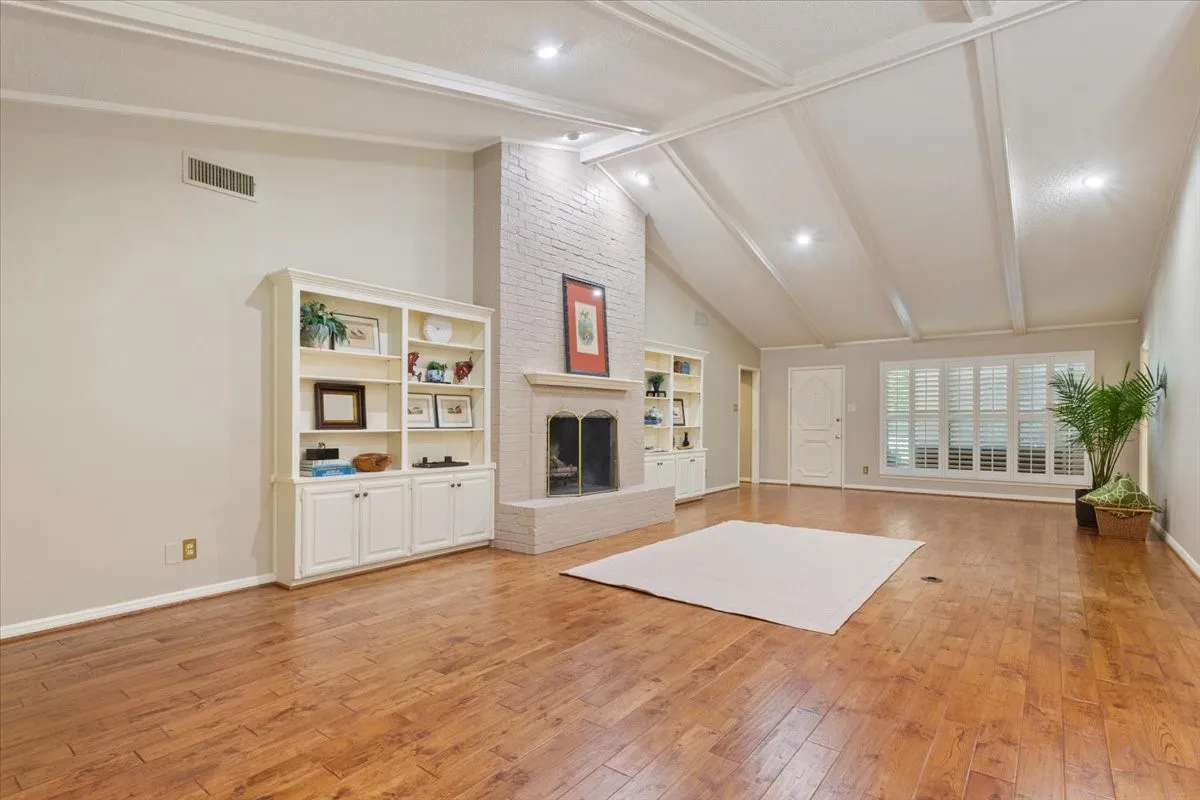 Vaulted ceiling with exposed beams and recessed lighting