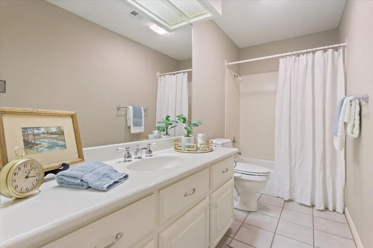 White vanity with integrated sink, chrome-finish faucet, and substantial storage cabinetry