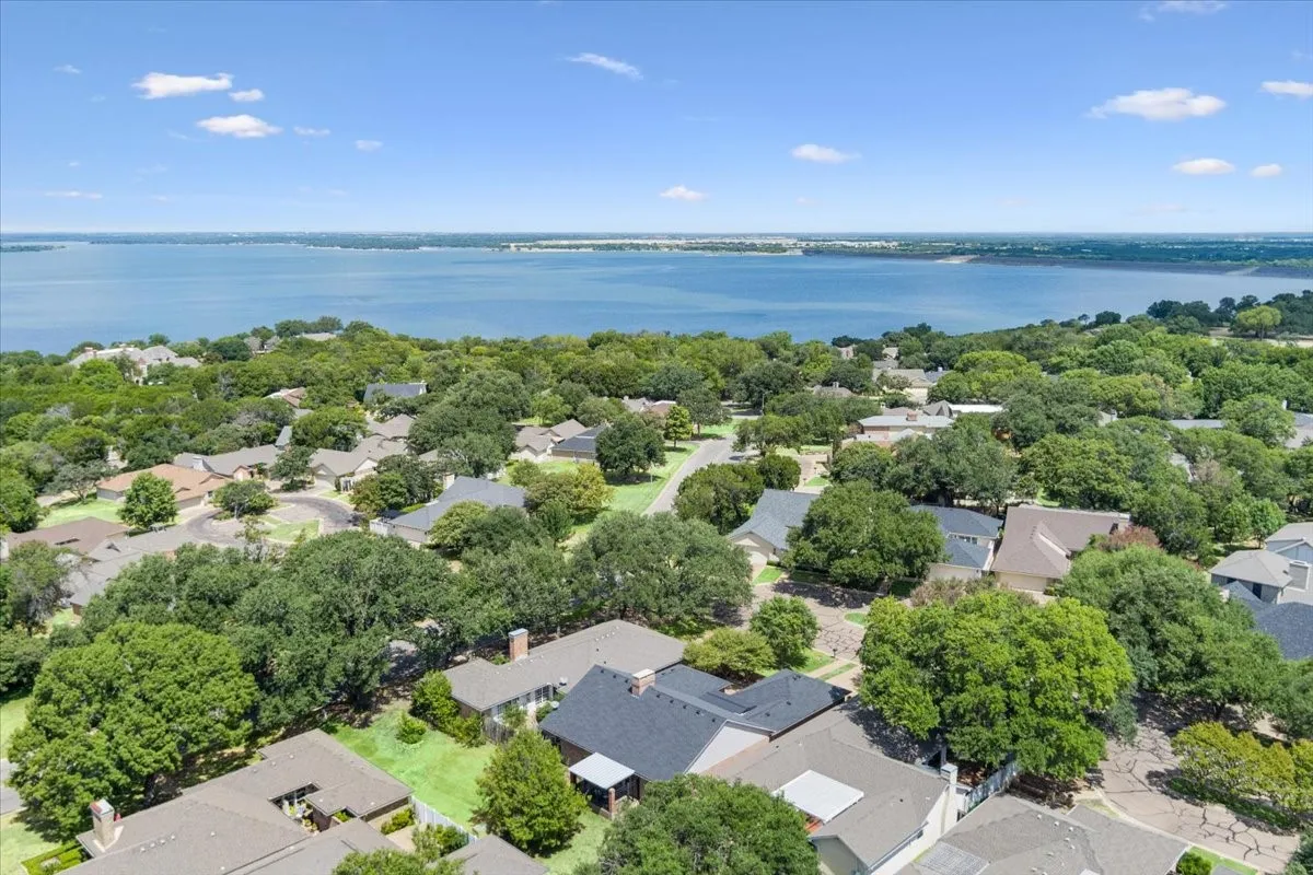 Aerial view the home and surrounding area nestled among mature trees