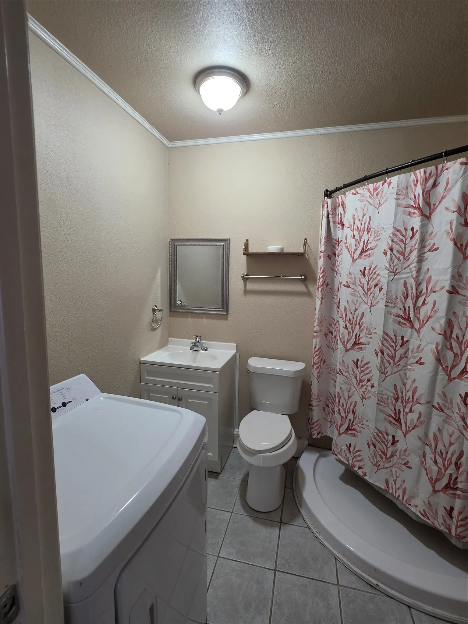 Tiled bathroom with a white vanity featuring a basin sink, toilet, and a corner shower stall