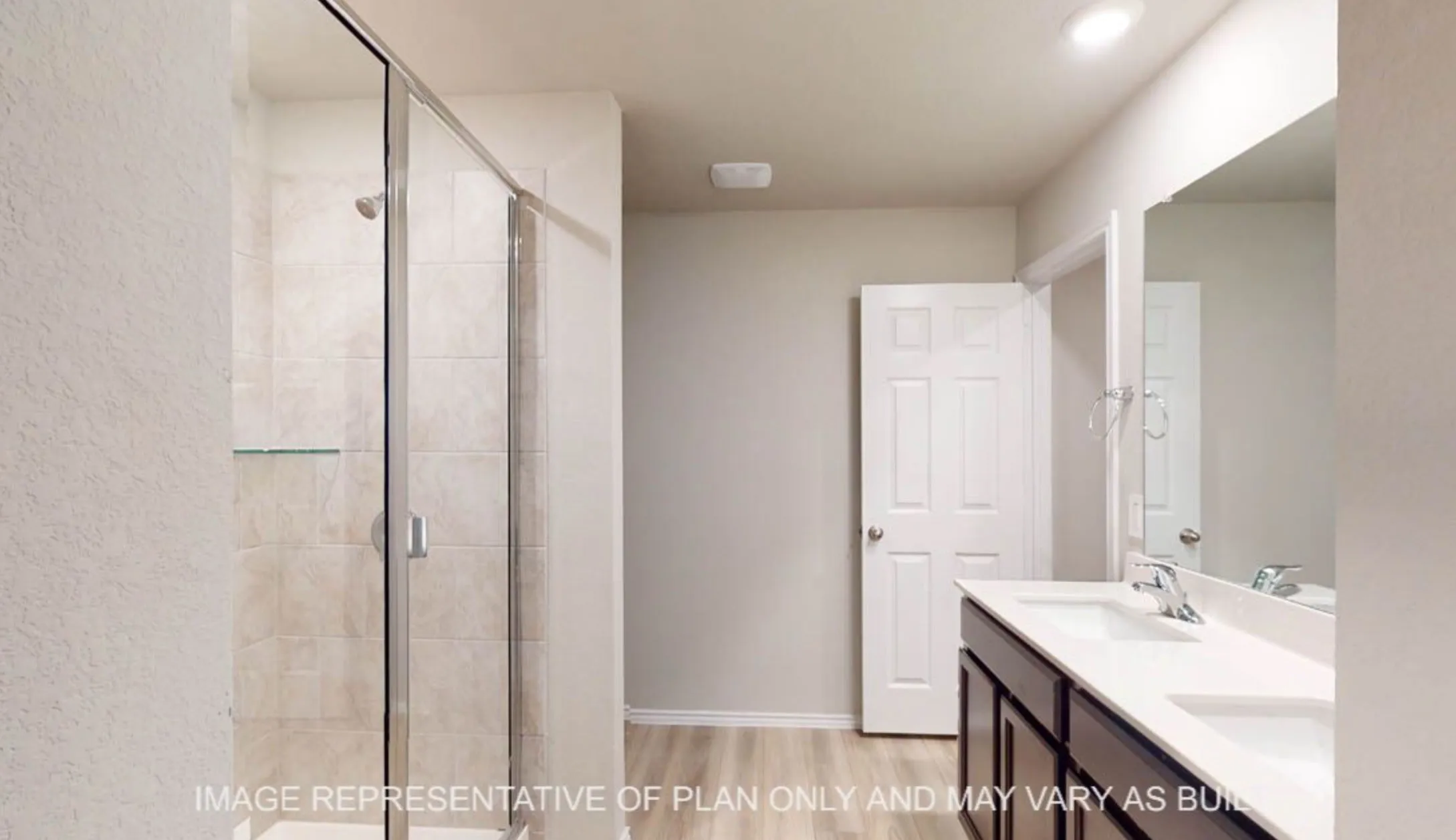Spa-inspired primary bathroom featuring a frameless glass shower enclosure with tile surround, dual-sink vanity with wood-finish cabinetry and white quartz countertop, large mirror with integrated lighting, and neutral tile flooring throughout