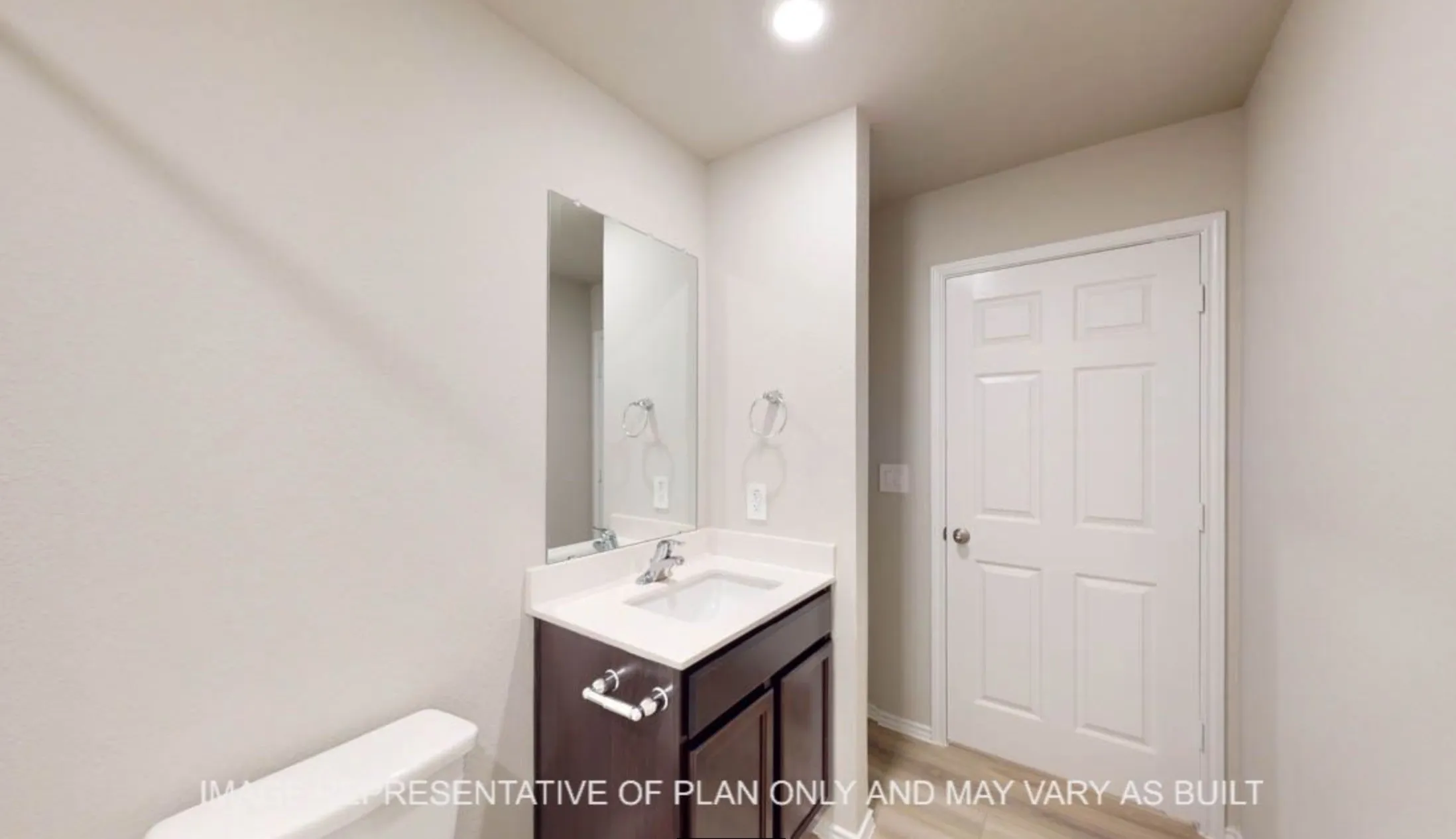 Vanity with a white countertop and integrated sink, chrome faucet, and rectangular mirror