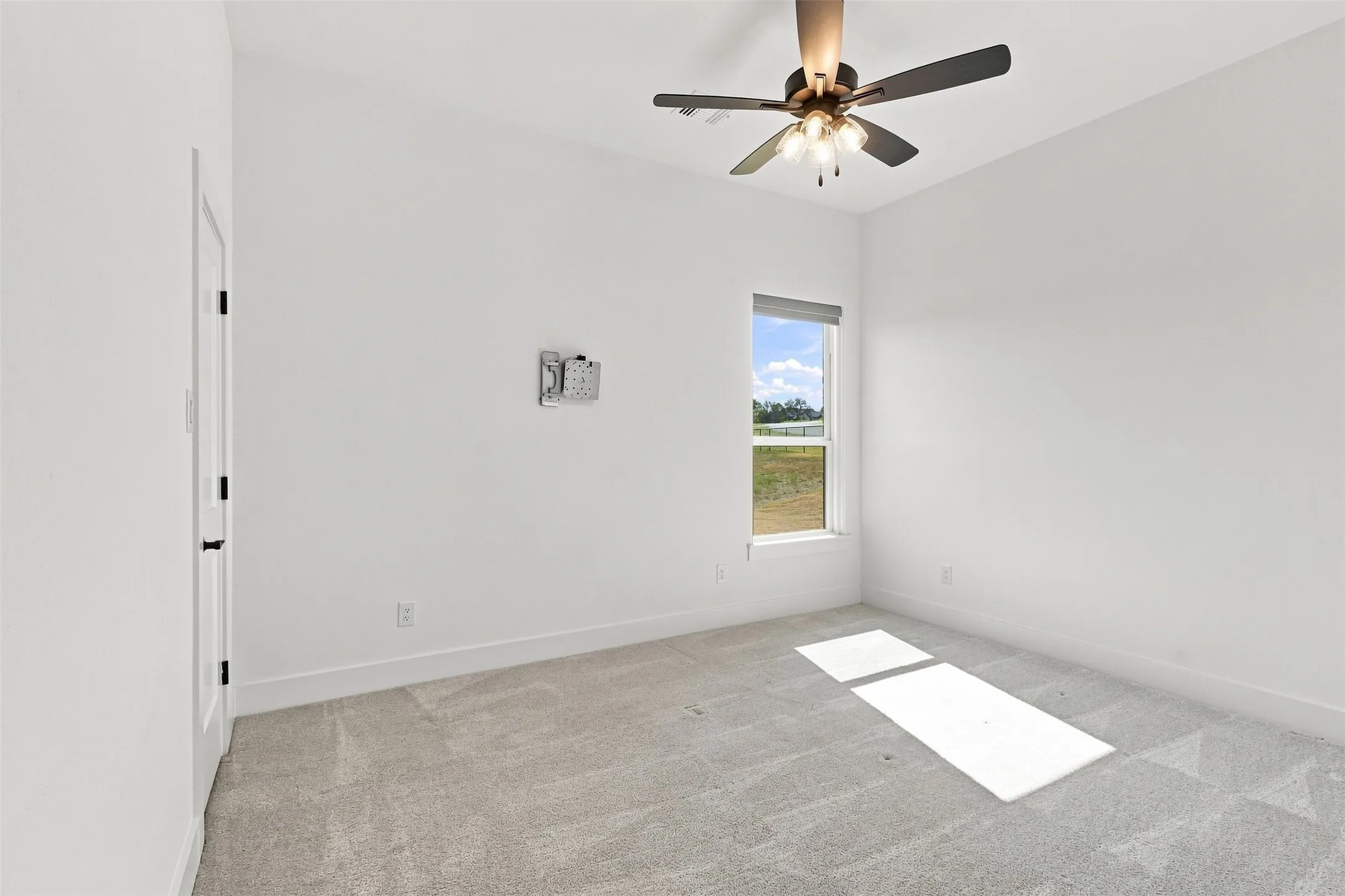 Bedroom with walk in closest and motorized blinds.