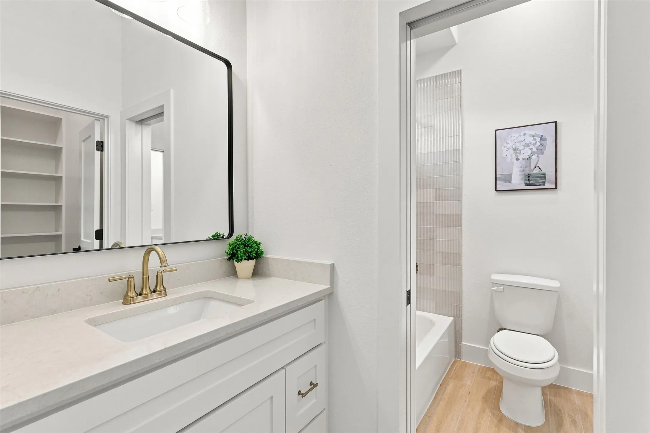 Jack and Jill White vanity with brass-finish hardware, light-toned countertop, and undermount sink