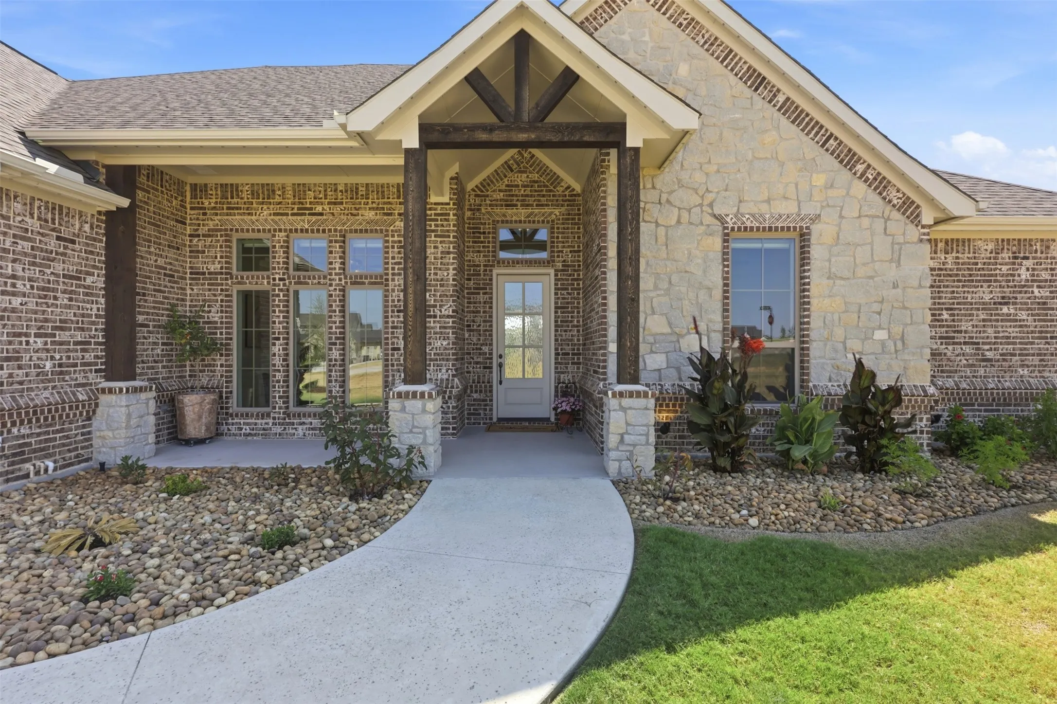 Stone and brick façade with a covered entry, gabled roofline.