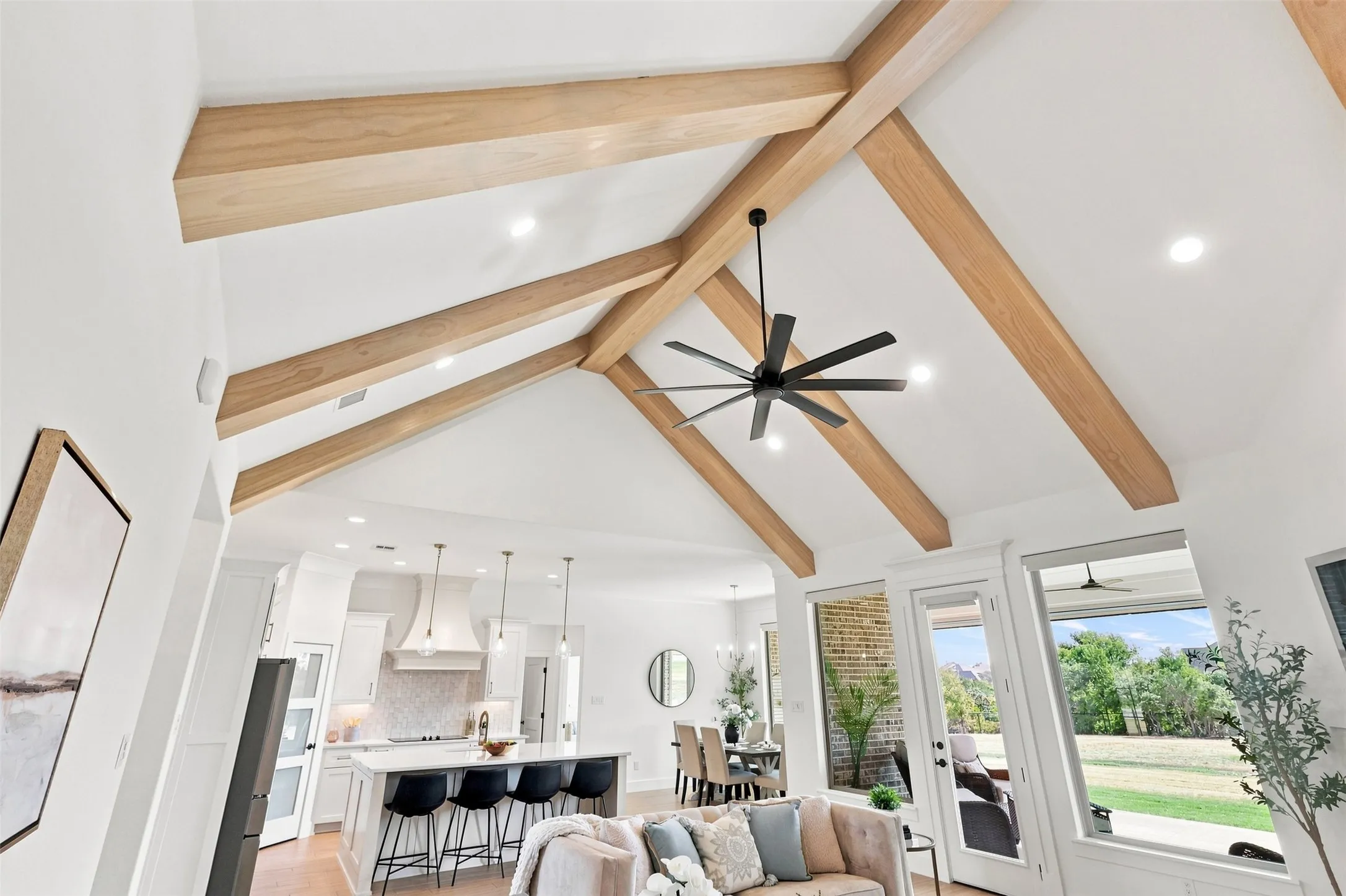 Vaulted ceiling with exposed wood beams and recessed lighting