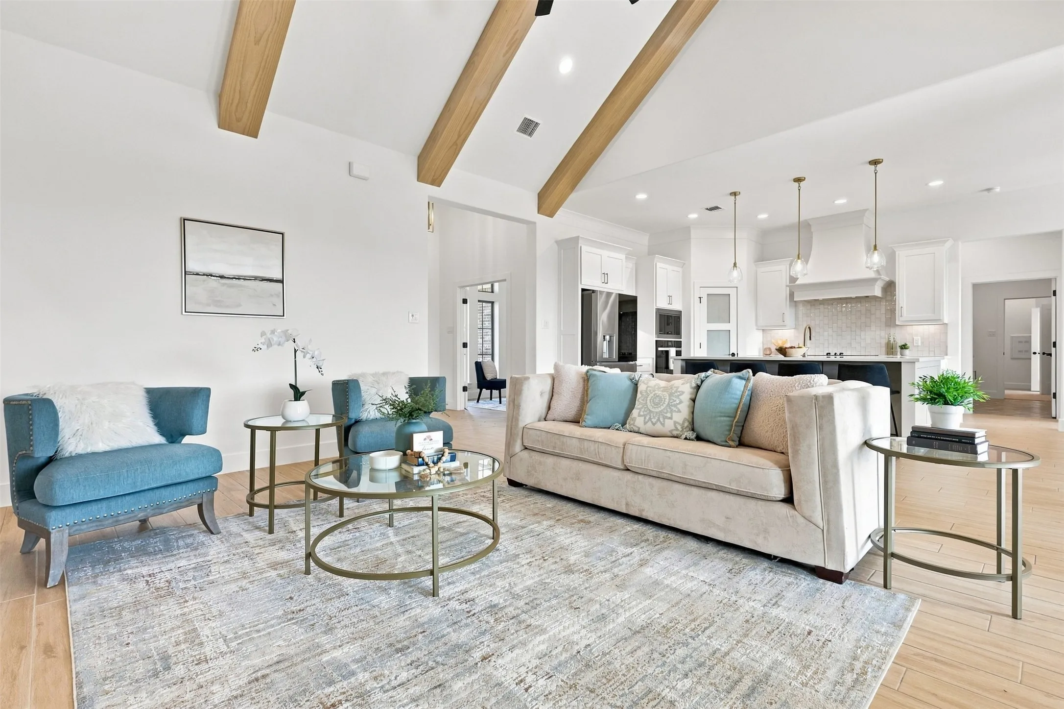 Vaulted ceiling with exposed wood beams, wood-finish flooring, recessed lighting, white cabinetry, and pendant lighting