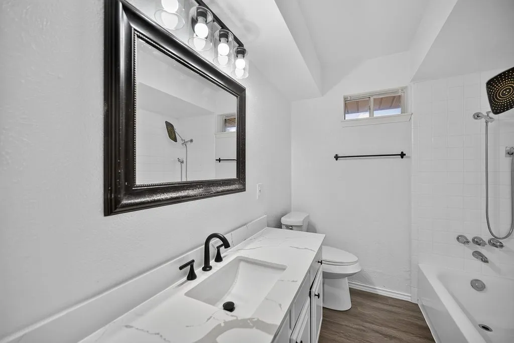 White vanity with a rectangular undermount sink, matte black faucet, and patterned countertop
