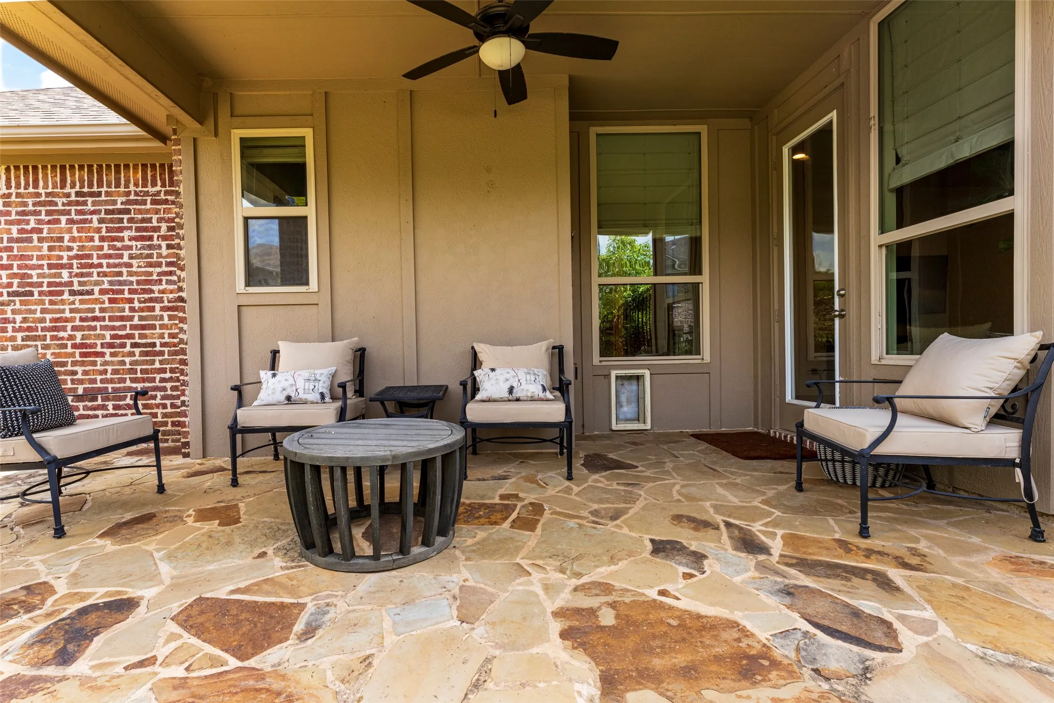 Covered Flagstone Patio: Unwind after a long day in this inviting covered flagstone patio, offering a peaceful outdoor retreat for relaxing or entertaining. The low-maintenance yard provides a manageable outdoor space with room for pets to enjoy.