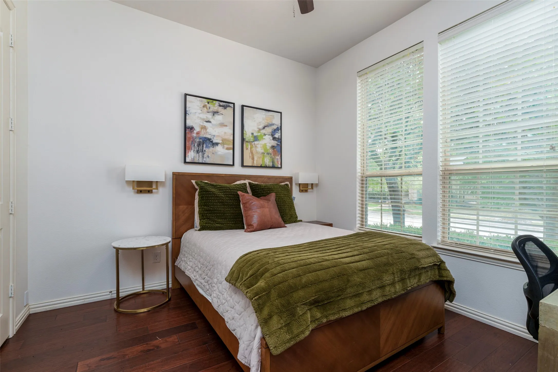 Versatile front-of-home room currently used as a bedroom, with excellent potential as a home office, study, or flex space. A wall of windows fills the room with abundant natural light, while rich wood floors and neutral finishes create a warm, inviting atmosphere. Flexible layout makes this space ideal for a bedroom, dedicated home office, or multi-purpose room.