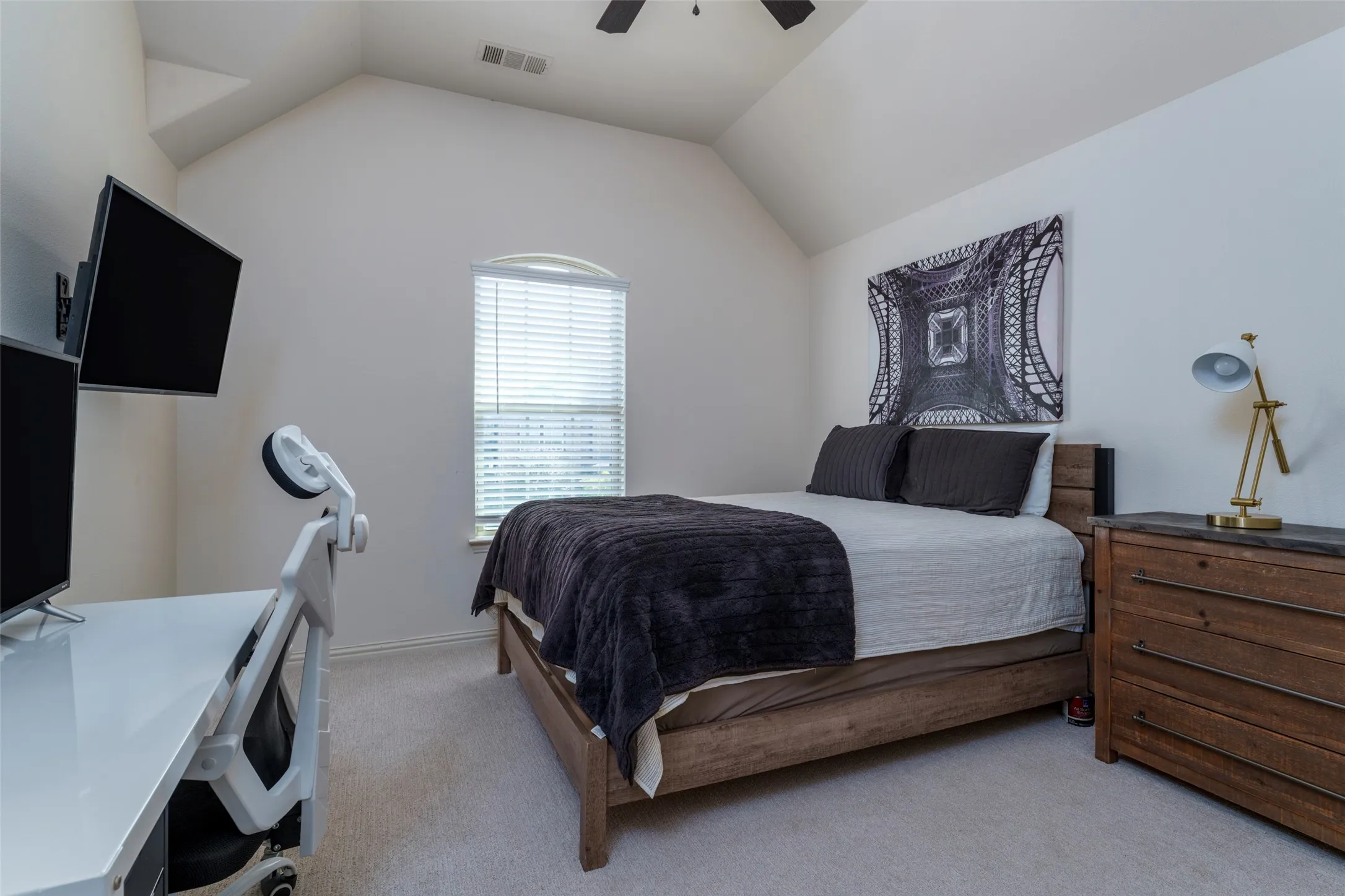 Upstairs Secondary Bedroom: Spacious upstairs secondary bedroom featuring high ceilings, a ceiling fan, neutral carpeting, and plenty of room for comfortable bedroom furniture. A versatile space ideal for family, guests, or a home office.