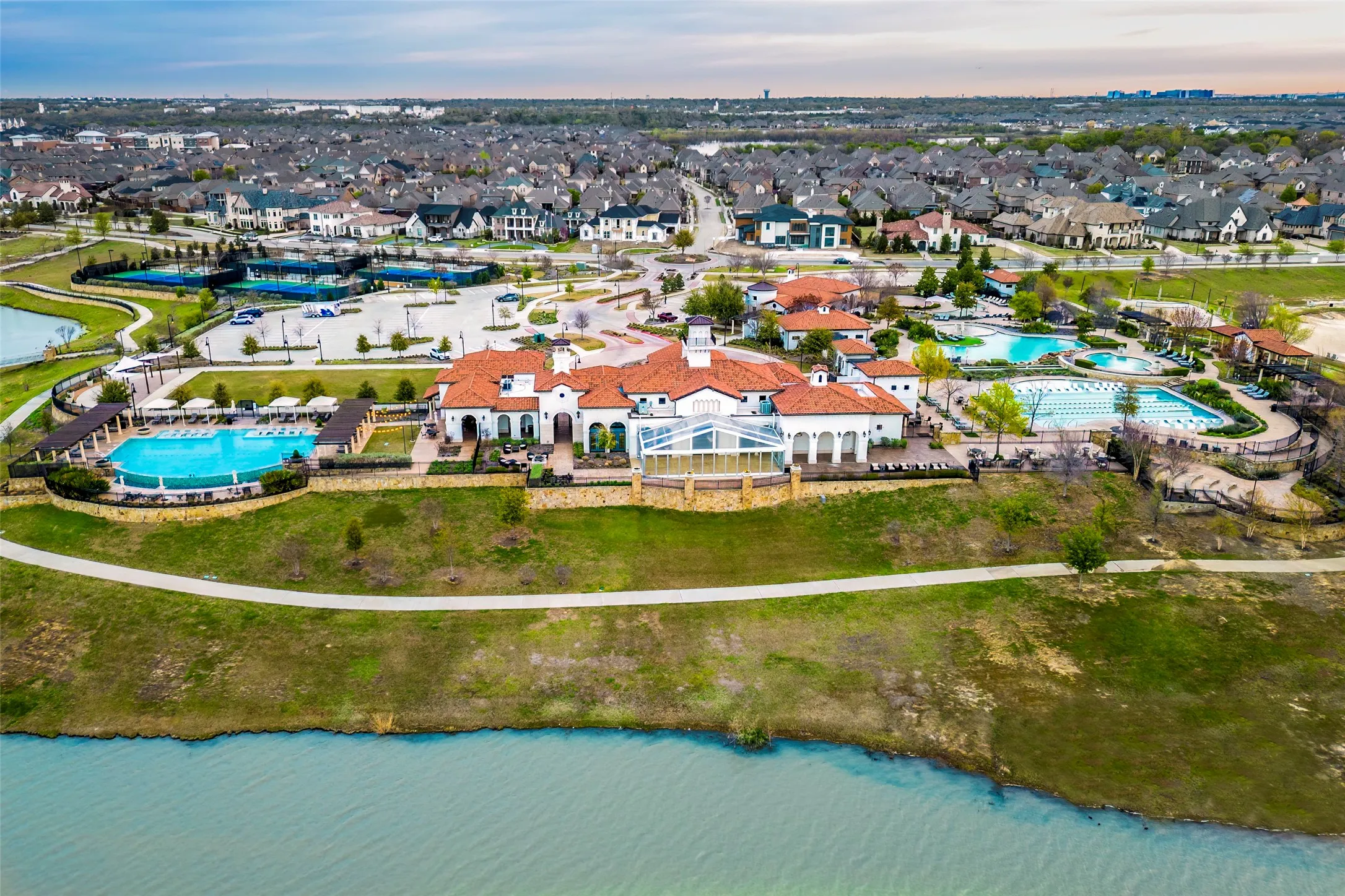 Aerial view of the sought-after Viridian master-planned community showcasing the private lake, scenic waterfront, and sailing opportunities. The Viridian Lake Club and Events Center create a vibrant hub for private events, recreation, and community gatherings, while miles of trails, parks, green spaces, and resort-style amenities enhance the exceptional lifestyle.