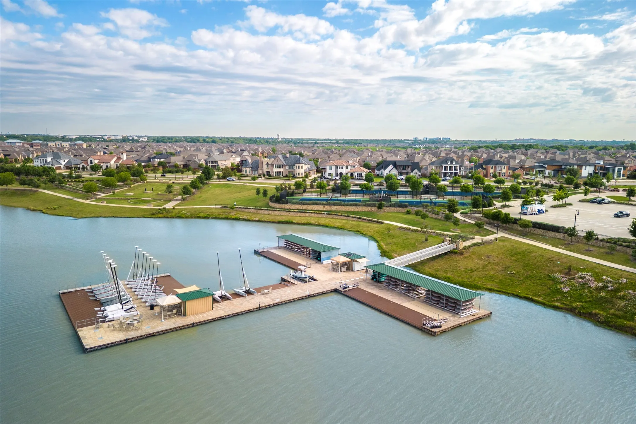 Aerial view of Viridian Lake showcasing the community’s scenic waterfront and dedicated sailing docks. Residents enjoy convenient access to sailboat storage and launching areas, surrounded by expansive lake views, walking trails, green spaces, and beautifully landscaped community amenities. A standout feature of the Viridian master-planned lifestyle in Arlington, TX.