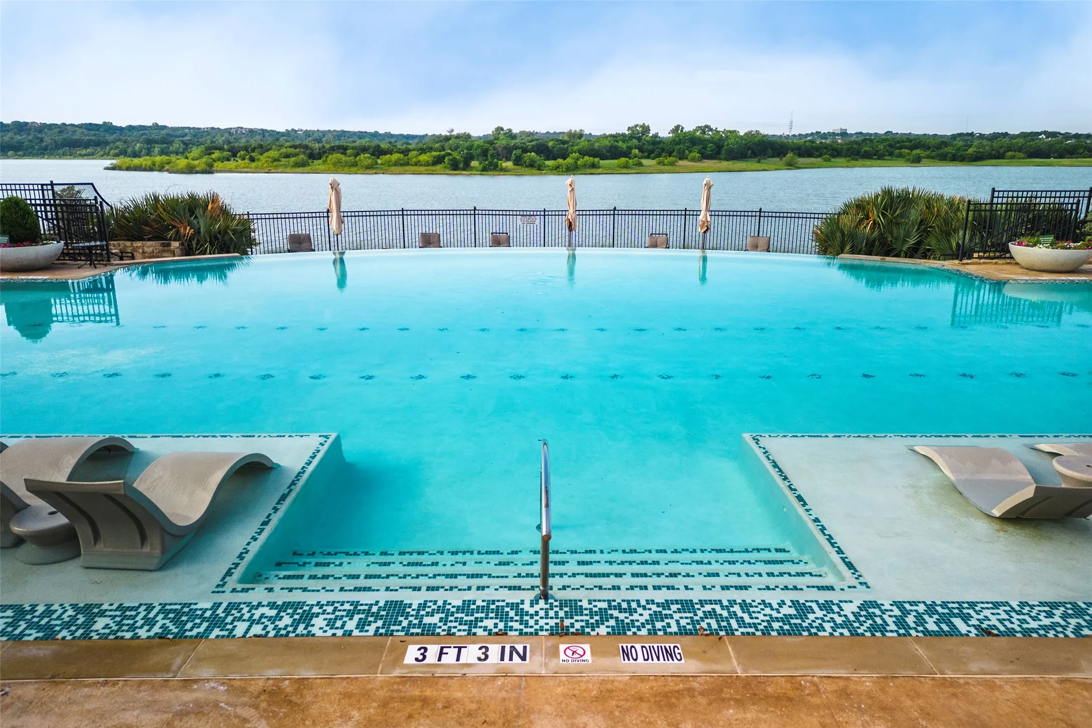 Viridian Community Pool — Resort-style community pool overlooking the scenic lake, offering a beautiful setting for swimming, relaxing and enjoying the outdoors. A standout amenity within the Viridian master-planned community, with spacious poolside areas and peaceful waterfront views.