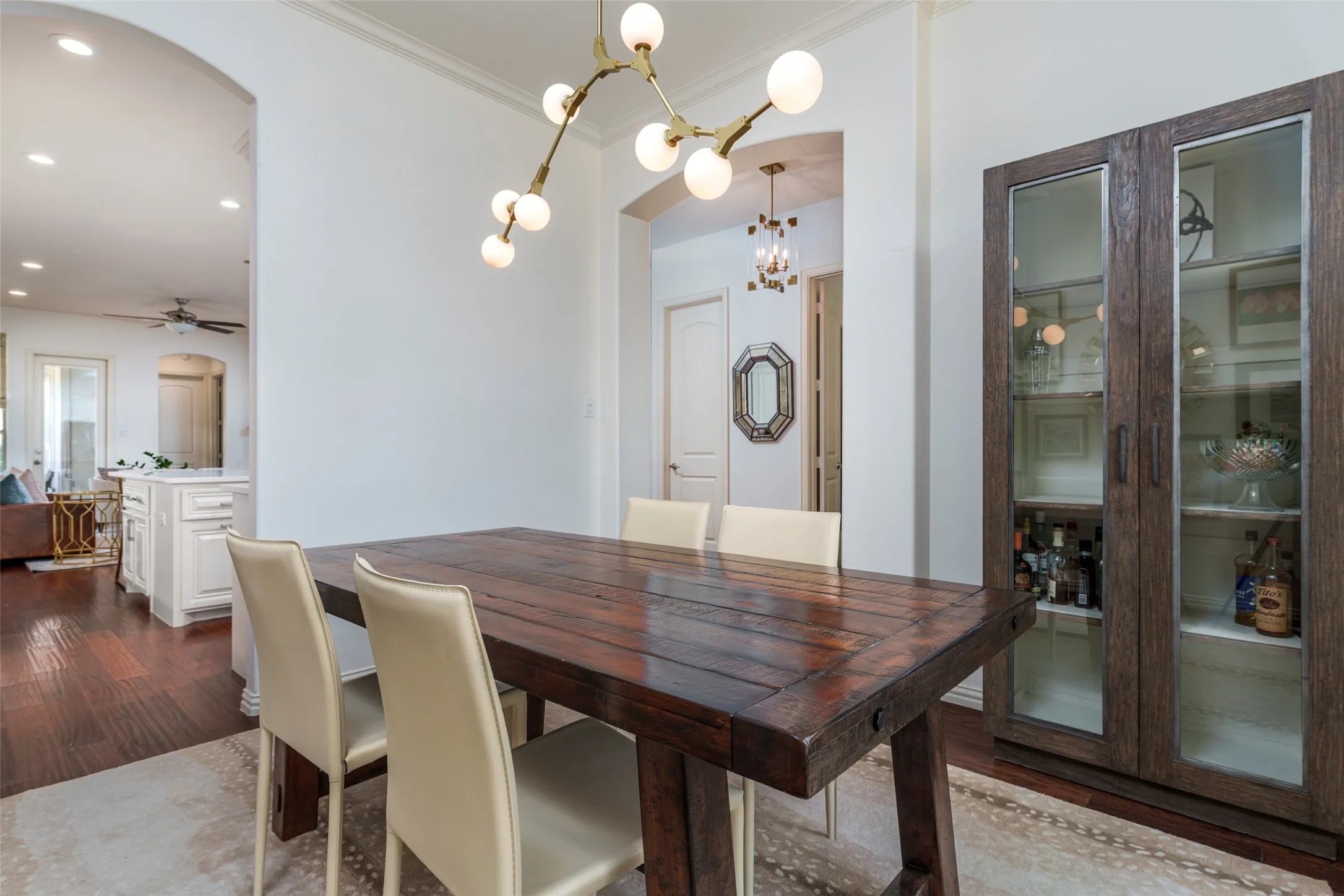 Spacious dining room designed for entertaining offers an easy flow directly from the kitchen and adjoining living spaces. Rich wood floors, recent interior paint, crisp architectural details, and an airy open feel create an inviting atmosphere. A striking Sputnik-style chandelier adds modern character, while the generous layout provides plenty of space for dining and hosting guests.