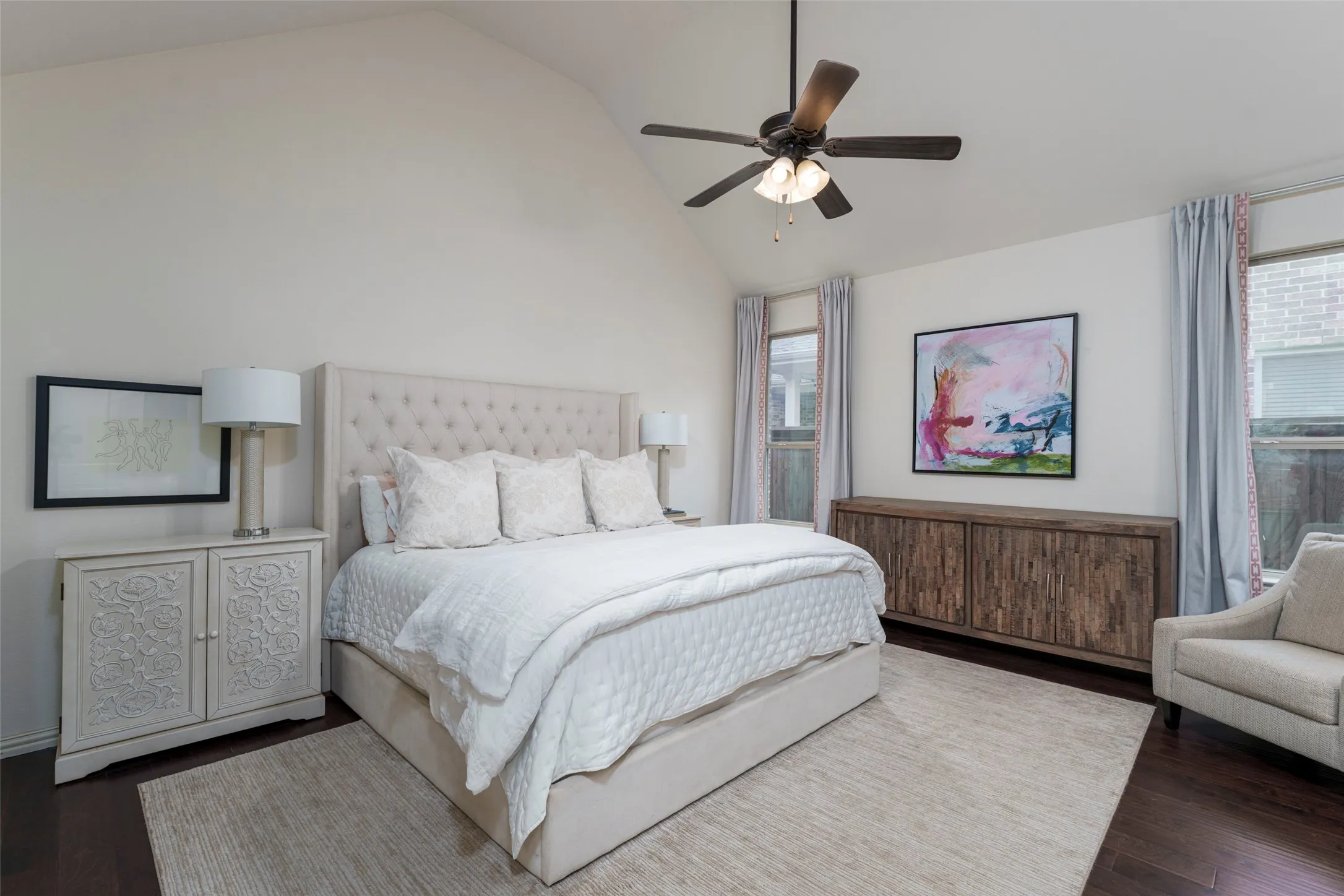 Primary Bedroom Retreat with high ceilings, rich wood floors, and abundant natural light. Large windows brighten the spacious first-floor bedroom, creating a comfortable and inviting retreat with plenty of room for a king-size bed and additional seating or furniture.