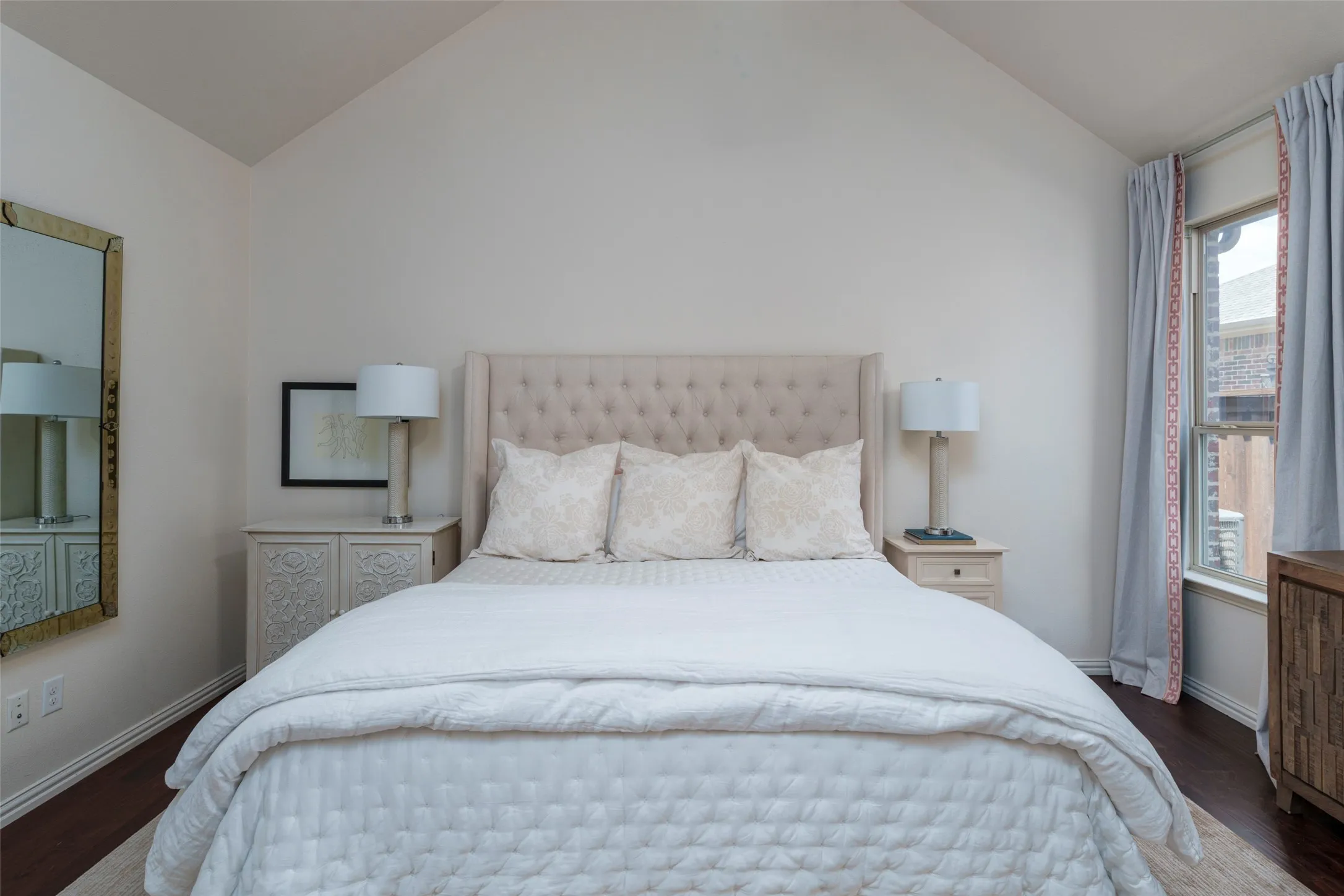 Spacious downstairs primary bedroom designed for privacy with a desirable split-bedroom layout. Generous wall space provides flexible options for furniture placement, while the spacious floor plan easily accommodates a king-size bed. Rich wood floors and abundant natural light create a comfortable, inviting primary retreat.