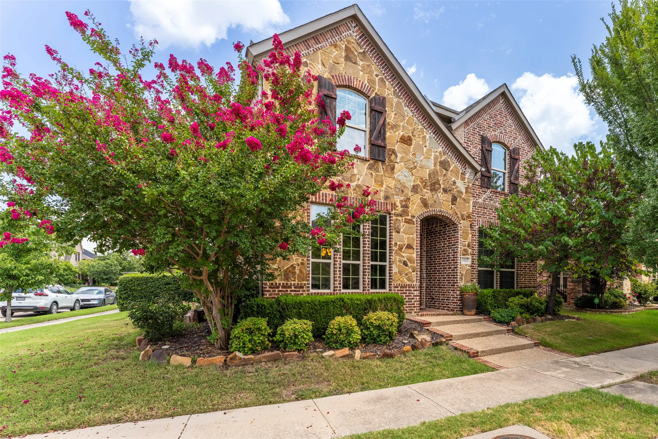 Stunning corner-lot home in the highly sought-after Viridian master-planned community in Arlington, TX, featuring exceptional curb appeal with manicured landscaping, mature trees, vibrant crepe myrtles, and natural stone accents. Beautiful brick and stone exterior details create timeless Texas charm, while the welcoming entry enhances the home's distinctive character. Ideally located in Viridian with highly regarded H-E-B ISD schools and access to the community's exceptional amenities.