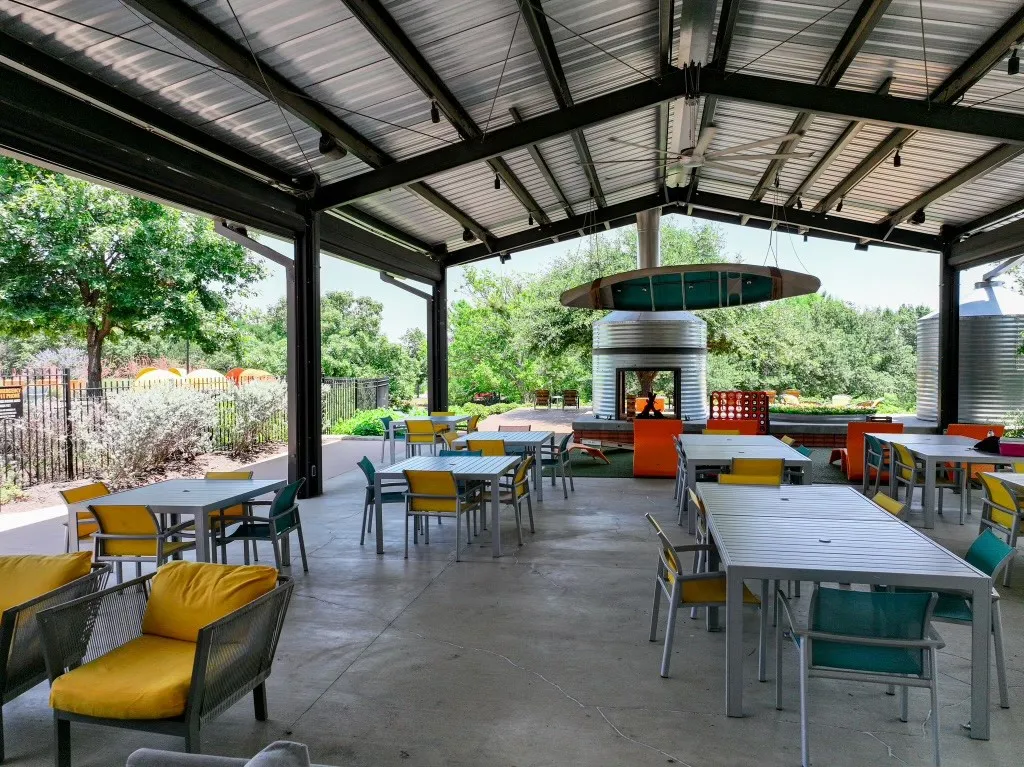 Expansive covered patio featuring a corrugated metal roof, exposed structural beams, and a concrete floor