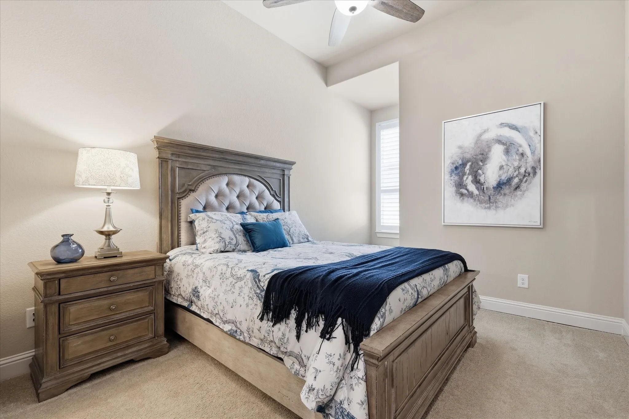 Guest bedroom Carpeted bedroom featuring a vaulted ceiling with a ceiling fan, a window with blinds, and a neutral color palette