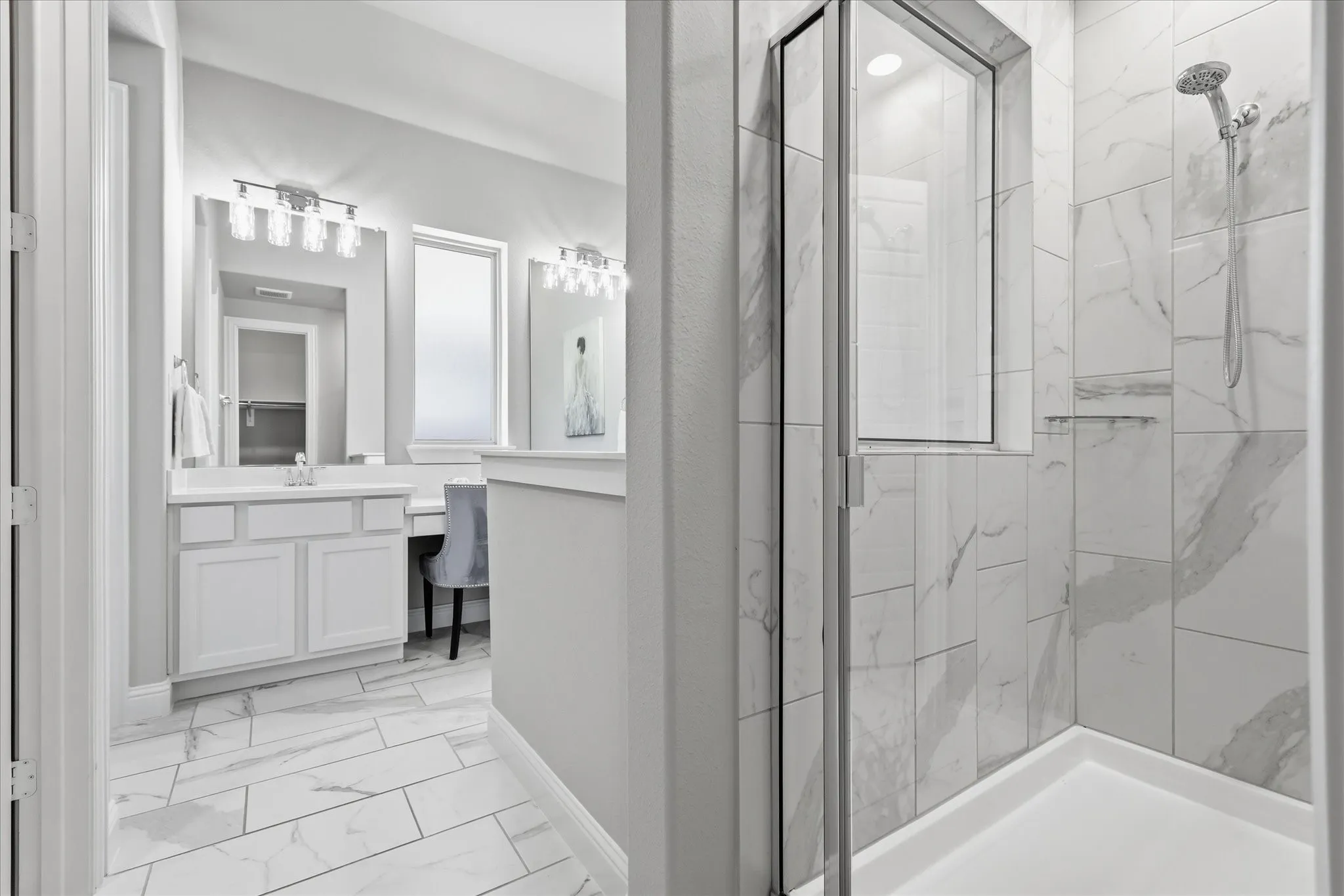 Shower with glass enclosure, white tiled walls, and built-in shelving