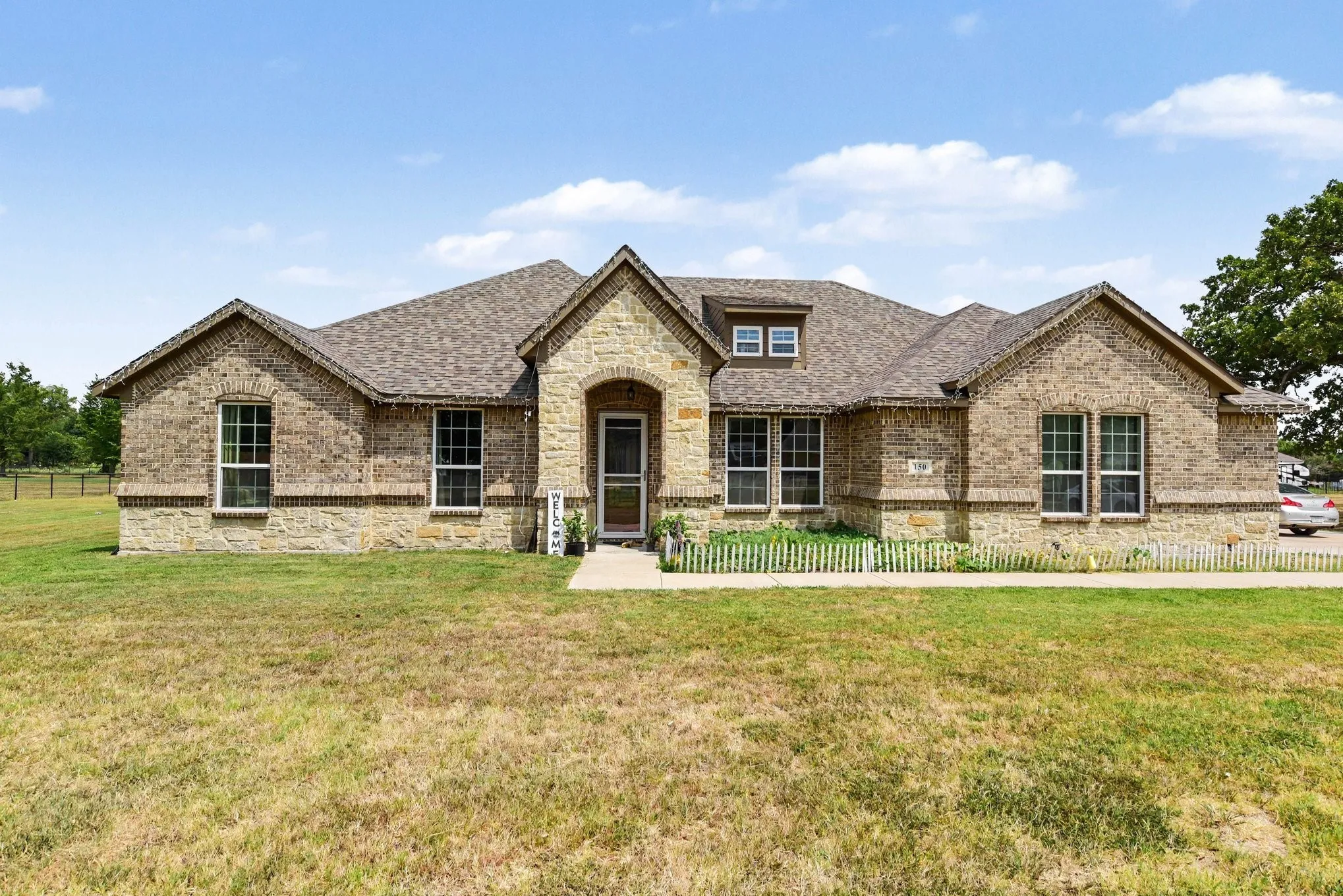 Elegant brick residence featuring a symmetrical facade with multiple gabled rooflines and architectural detail