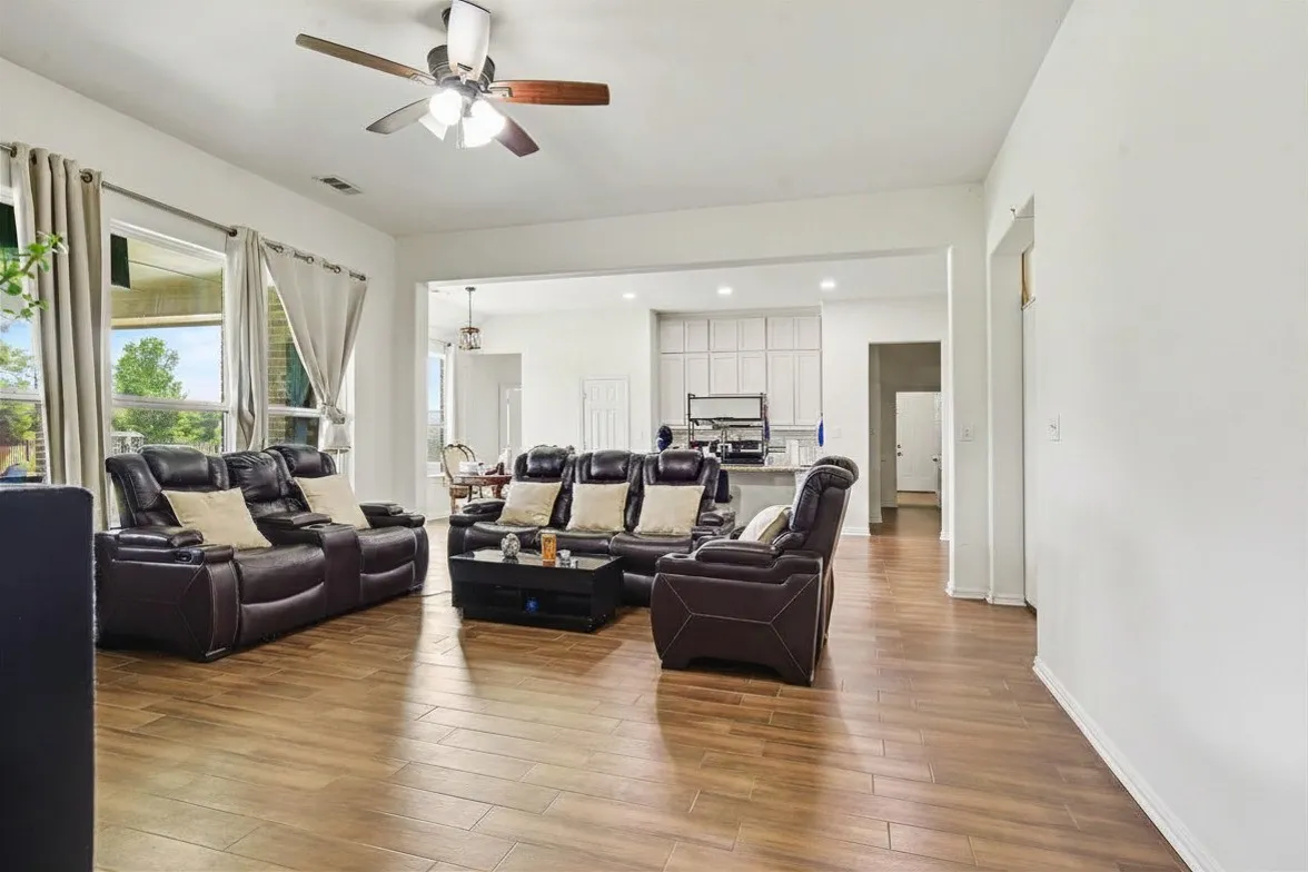 Wood-look ceramic tile  flooring, recessed lighting, and a ceiling fan with integrated lighting