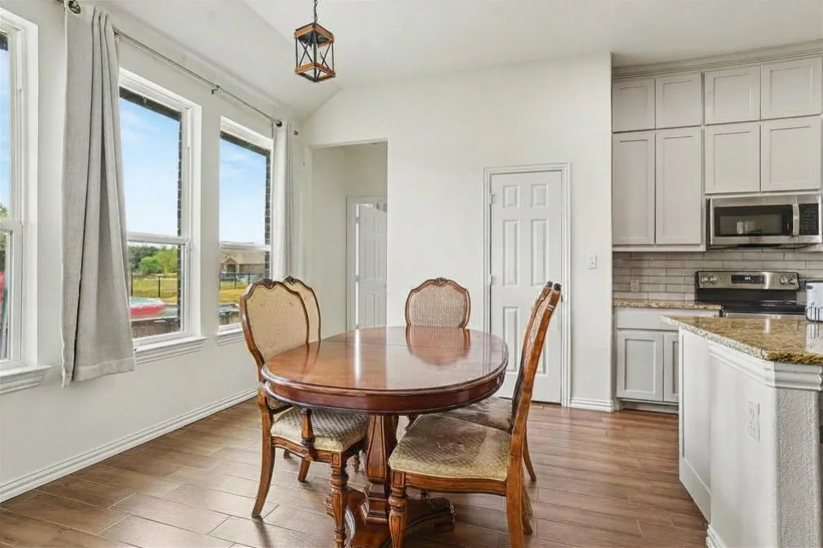 Kitchen area with light-toned cabinetry, stainless steel appliances, and a tiled backsplash