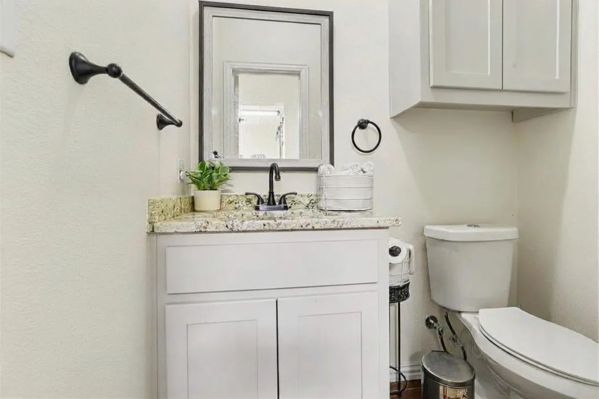 Vanity with a granite-style countertop, undermount sink, and faucet