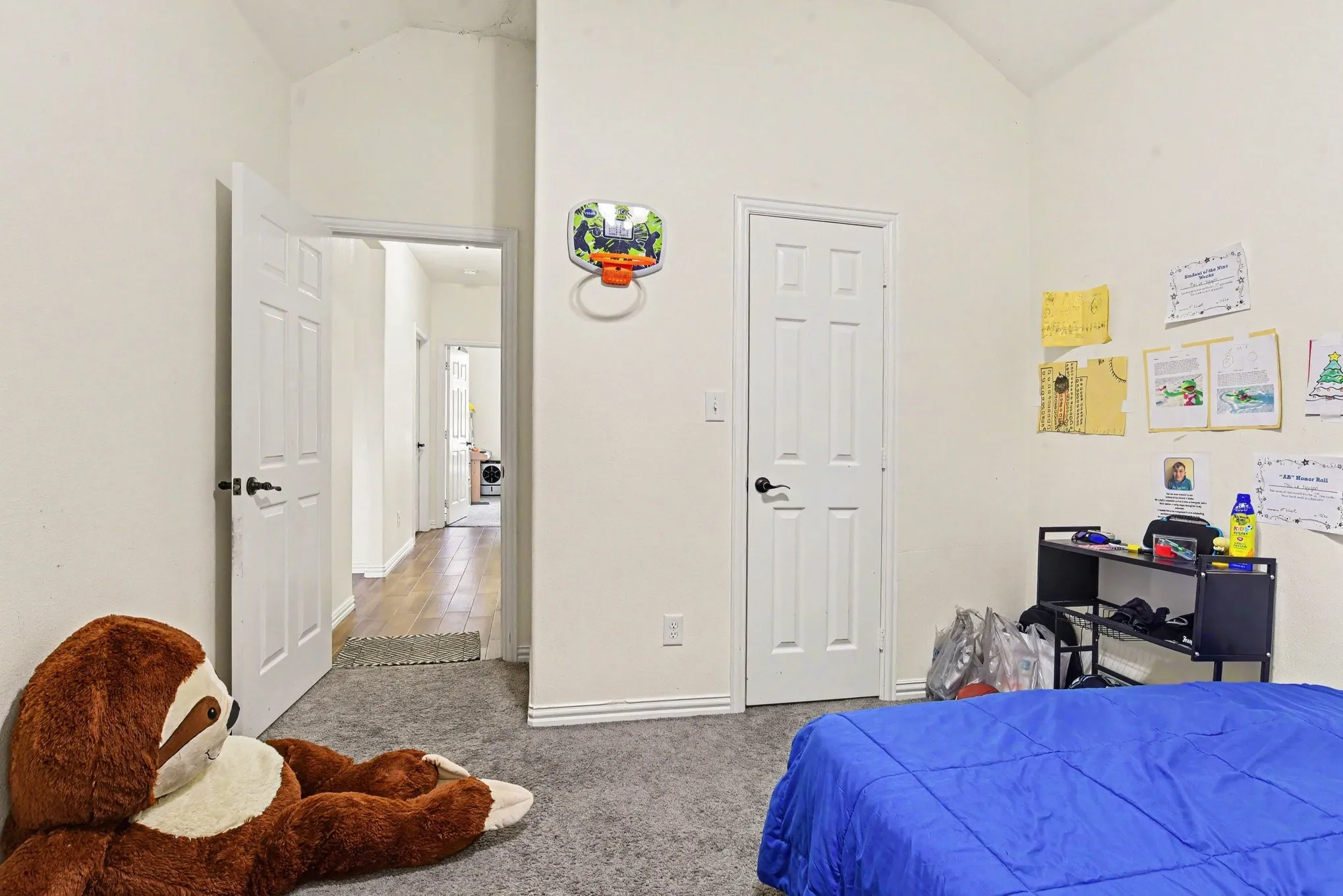 Vaulted ceiling, carpet, and neutral tone walls