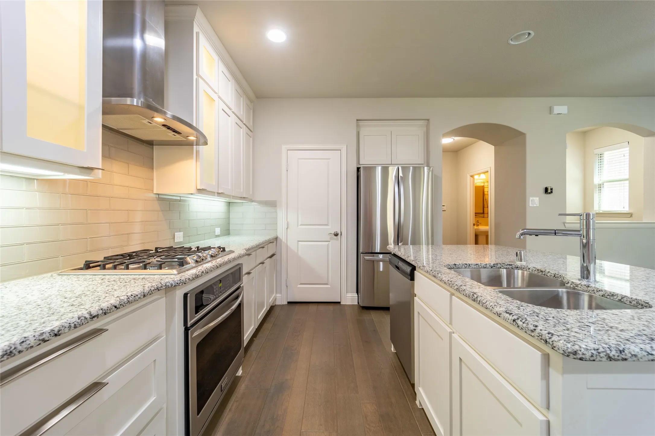 Lighted cabinets with frosted glass accent this kitchen beautifully