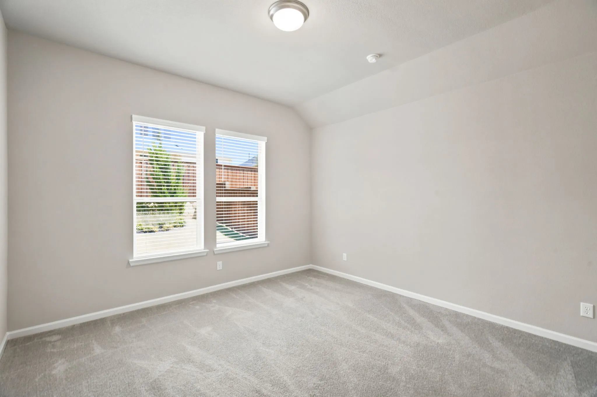 Bright and airy bedroom flooded with natural light through dual casement windows