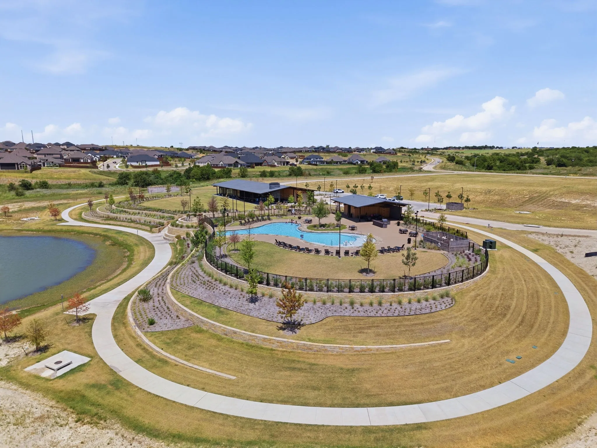 Community amenities featuring a swimming pool, clubhouse, walking paths, and a pond surrounded by landscaping