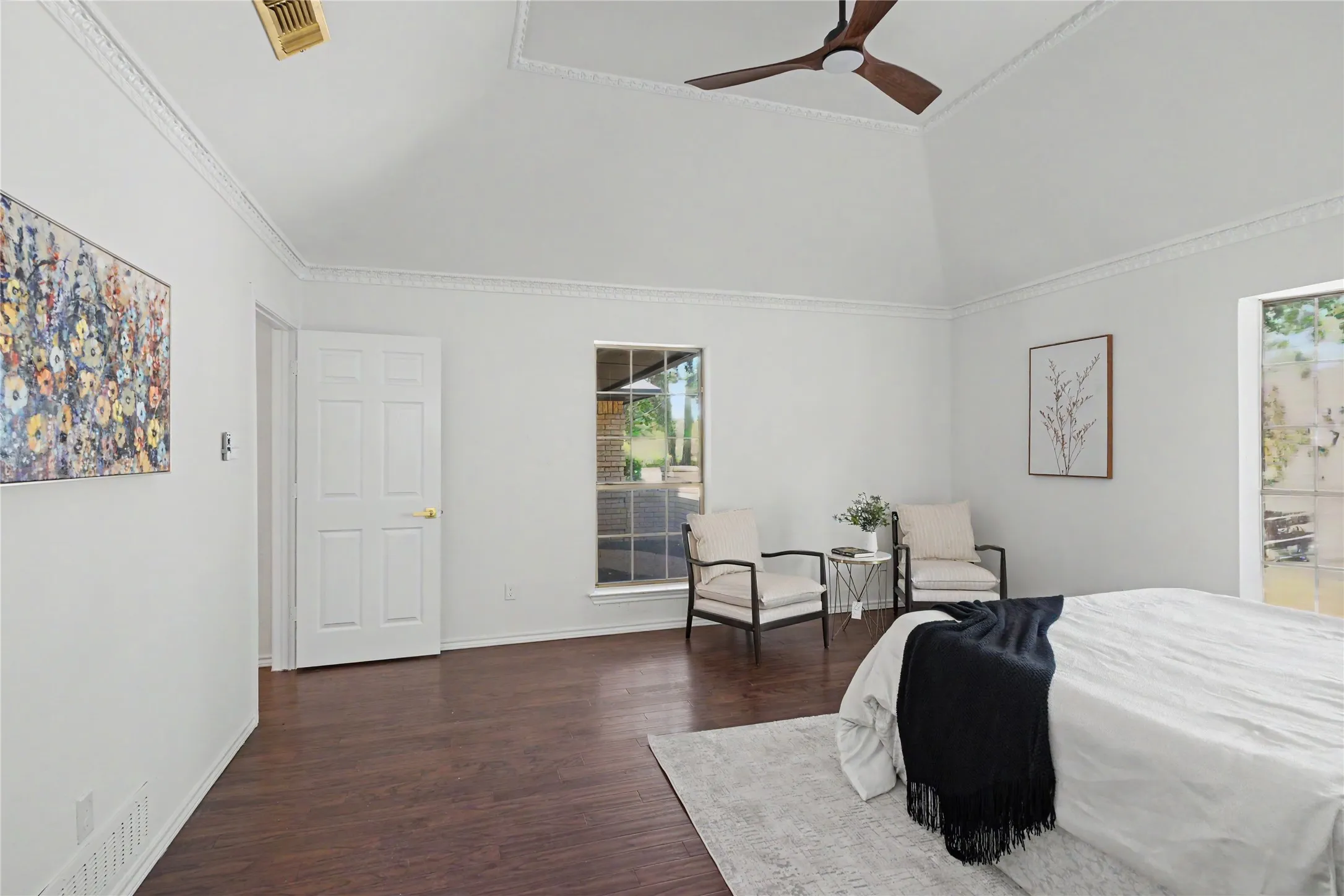 Vaulted ceiling with decorative molding, wood-finish flooring, and a modern ceiling fan