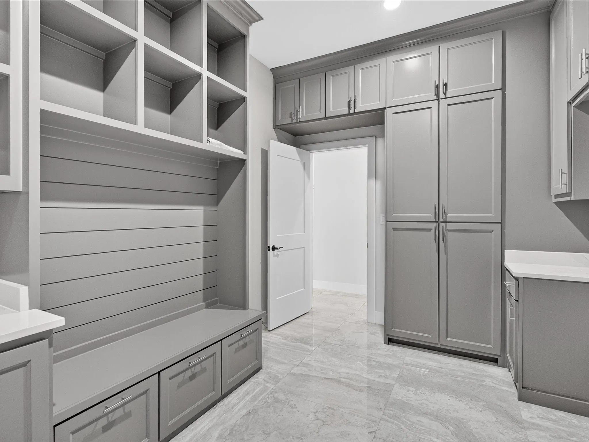 Built-in storage bench with drawers, open shelving, extensive cabinetry, and light-toned flooring