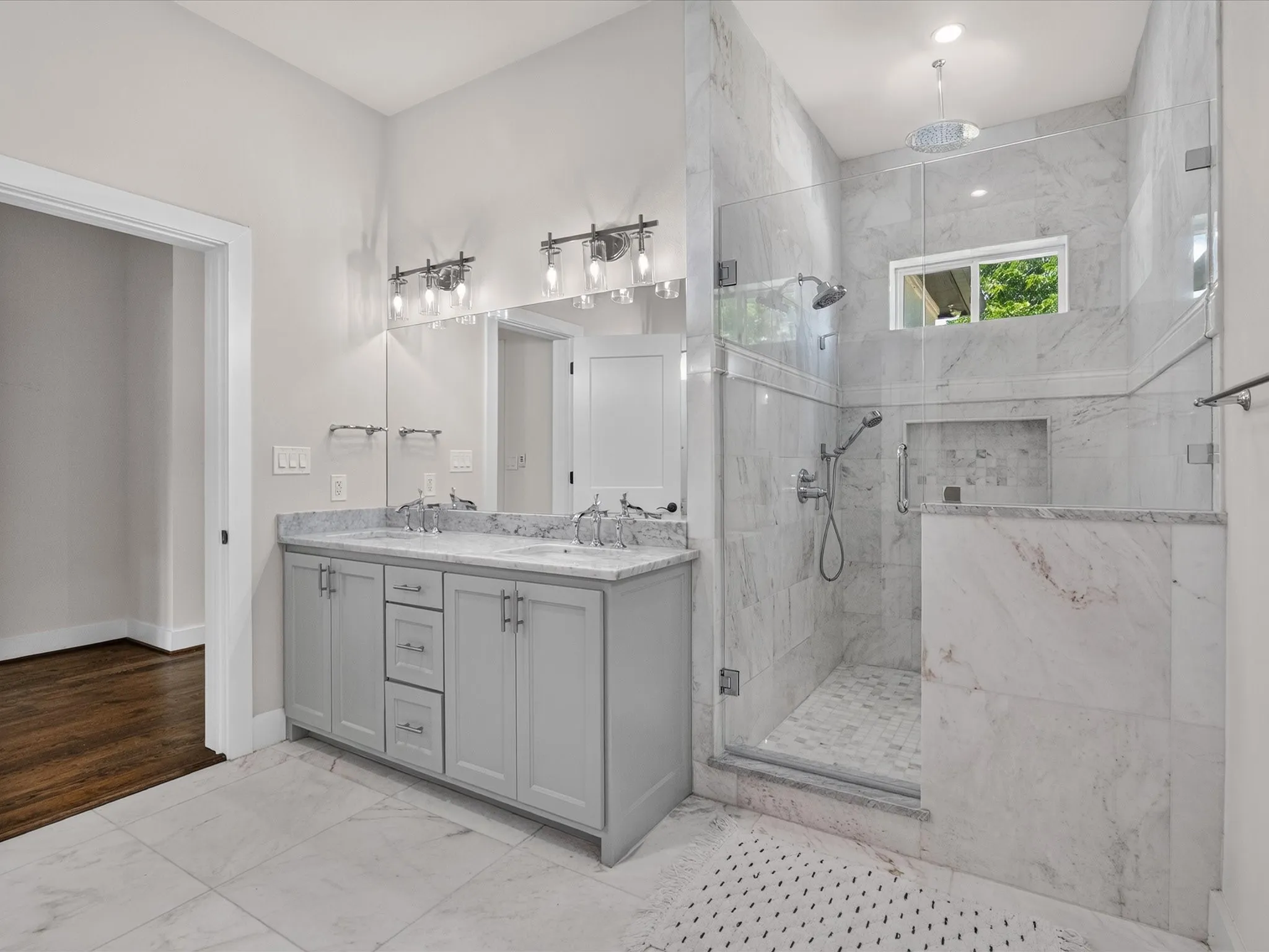 Spacious bathroom featuring a dual vanity with a stone countertop, a walk-in shower with glass enclosure, white tile flooring, and recessed lighting