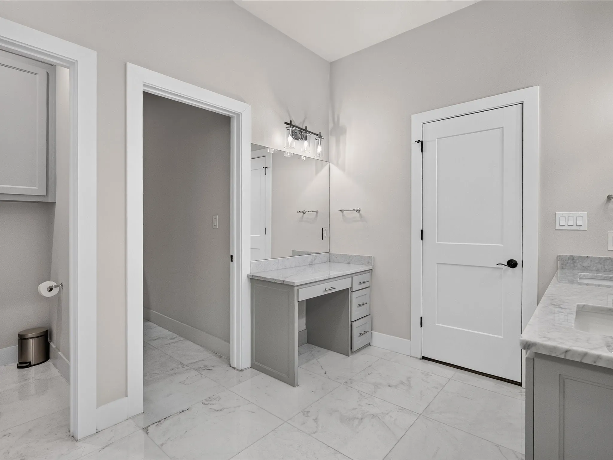 Vanity area featuring a built-in makeup desk with drawers, stone countertop, and an overhead light fixture