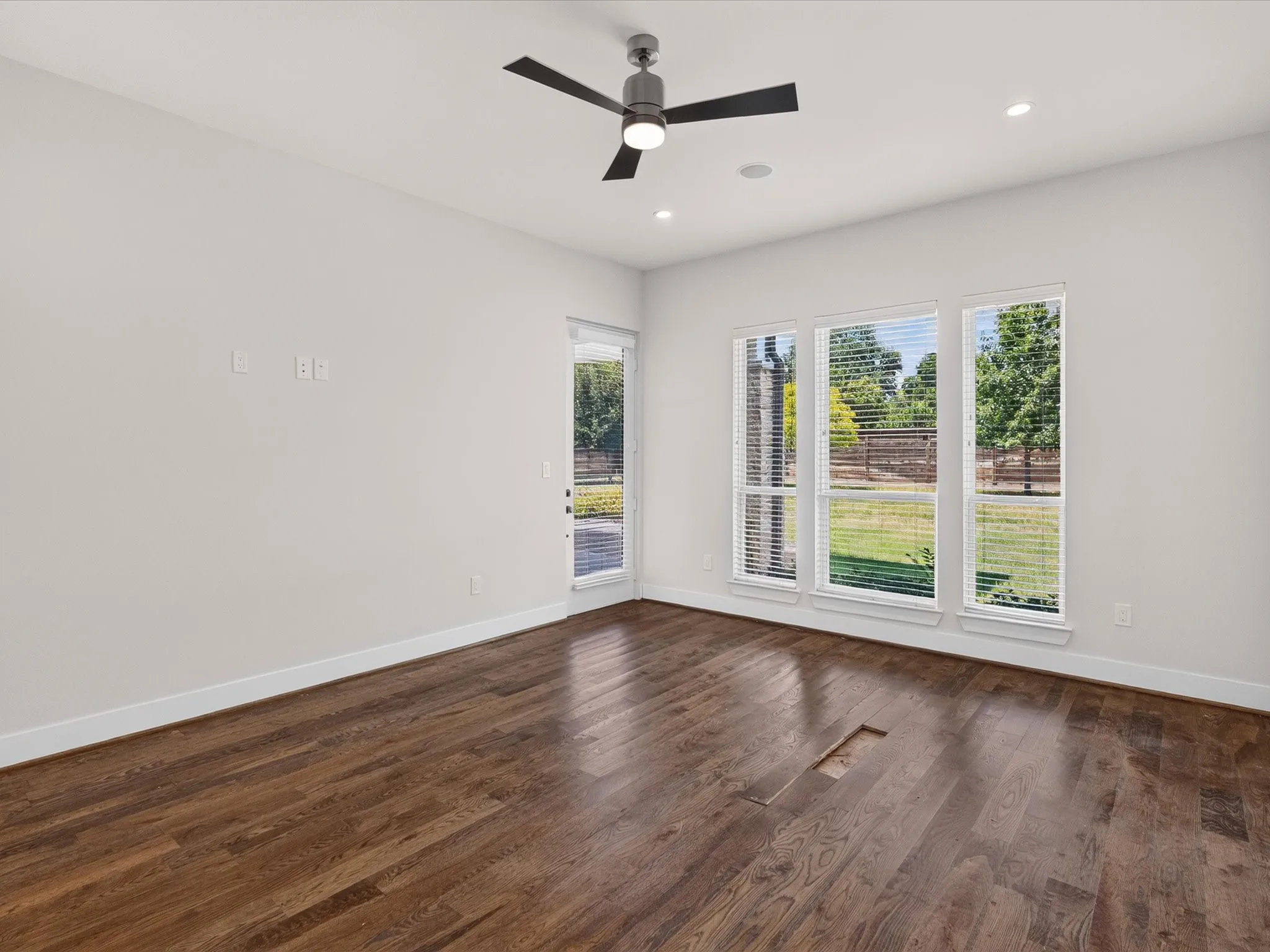 Hardwood-finish flooring with a modern ceiling fan, recessed lighting, and multiple windows with blinds
