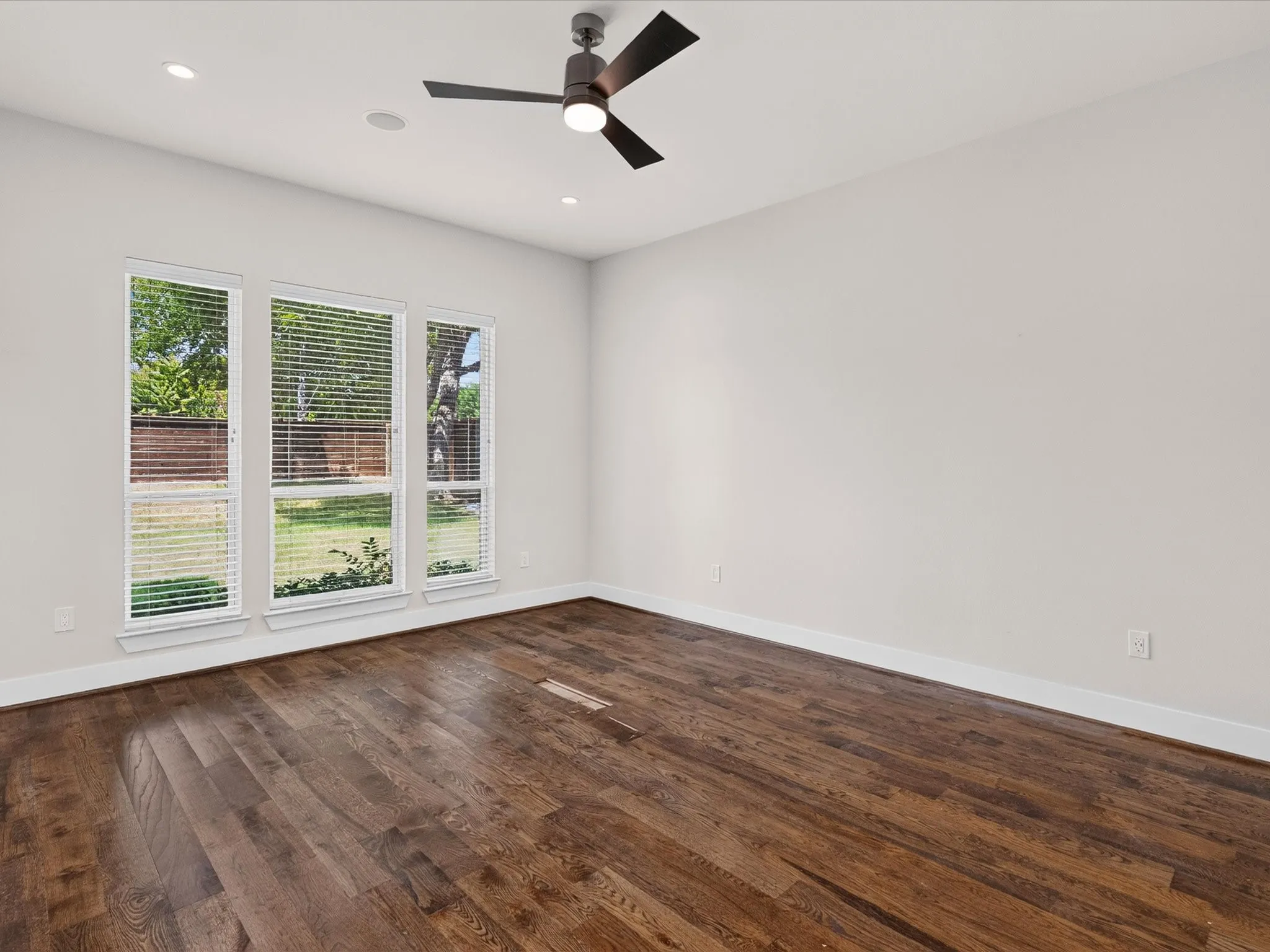 Wood-finish flooring, recessed lighting, and a ceiling fan with integrated light