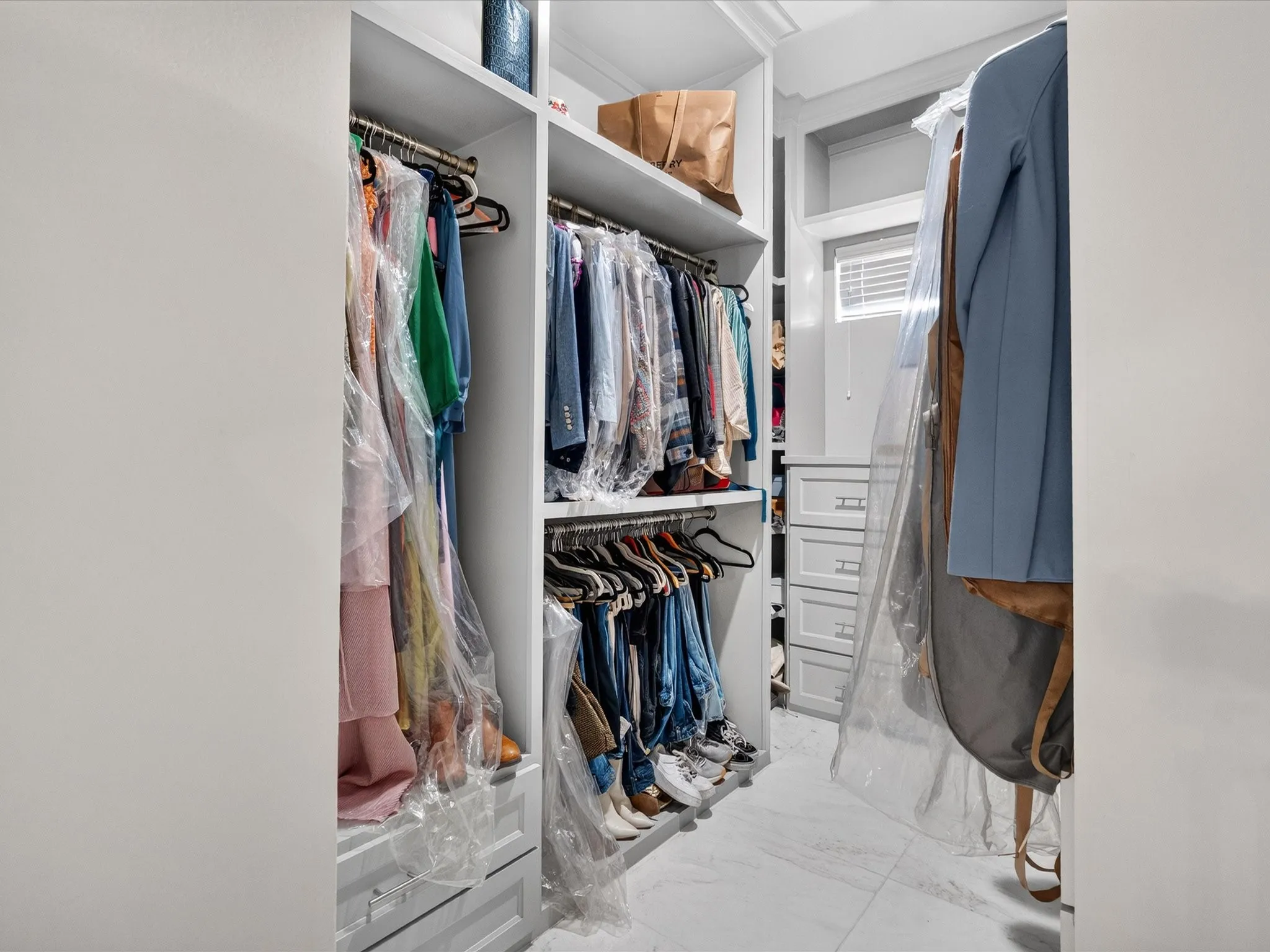 Custom closet system with built-in shelving, hanging rods, and drawers
