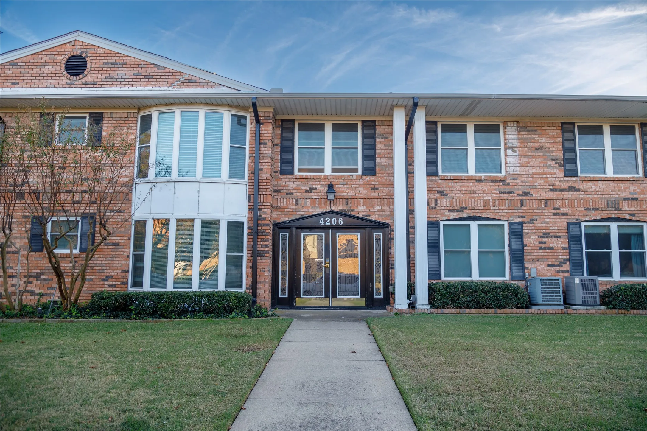 Brick exterior with a prominent bay window, dual entry doors secured by entry codes,