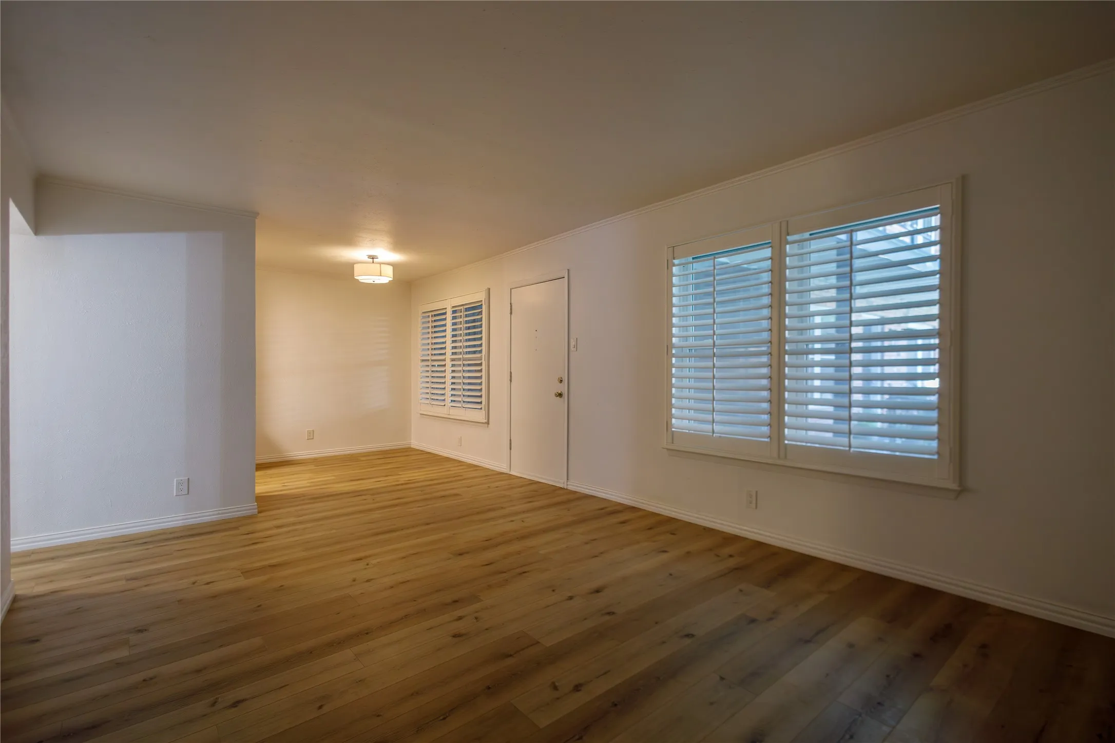 Wood-finish flooring, white walls, and a contemporary ceiling light fixture